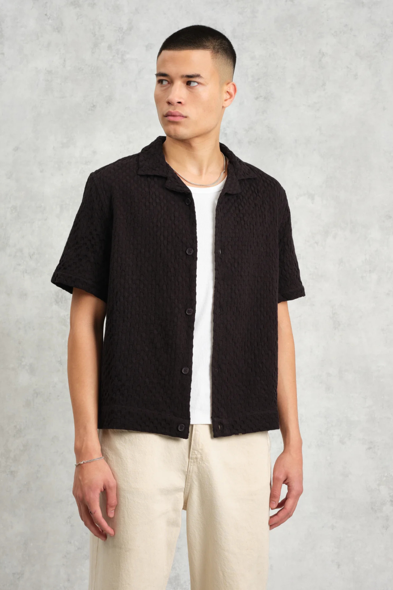 Model wearing the Wax London lido box dobby shirt in black. Front view