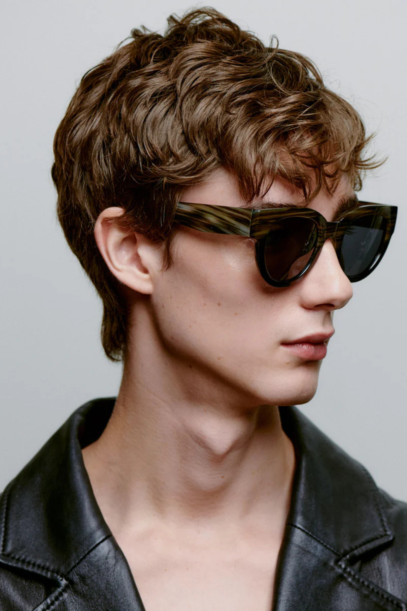 Model wearing the A. Kjaerbede lilly sunglasses in striped horn/black. Side view