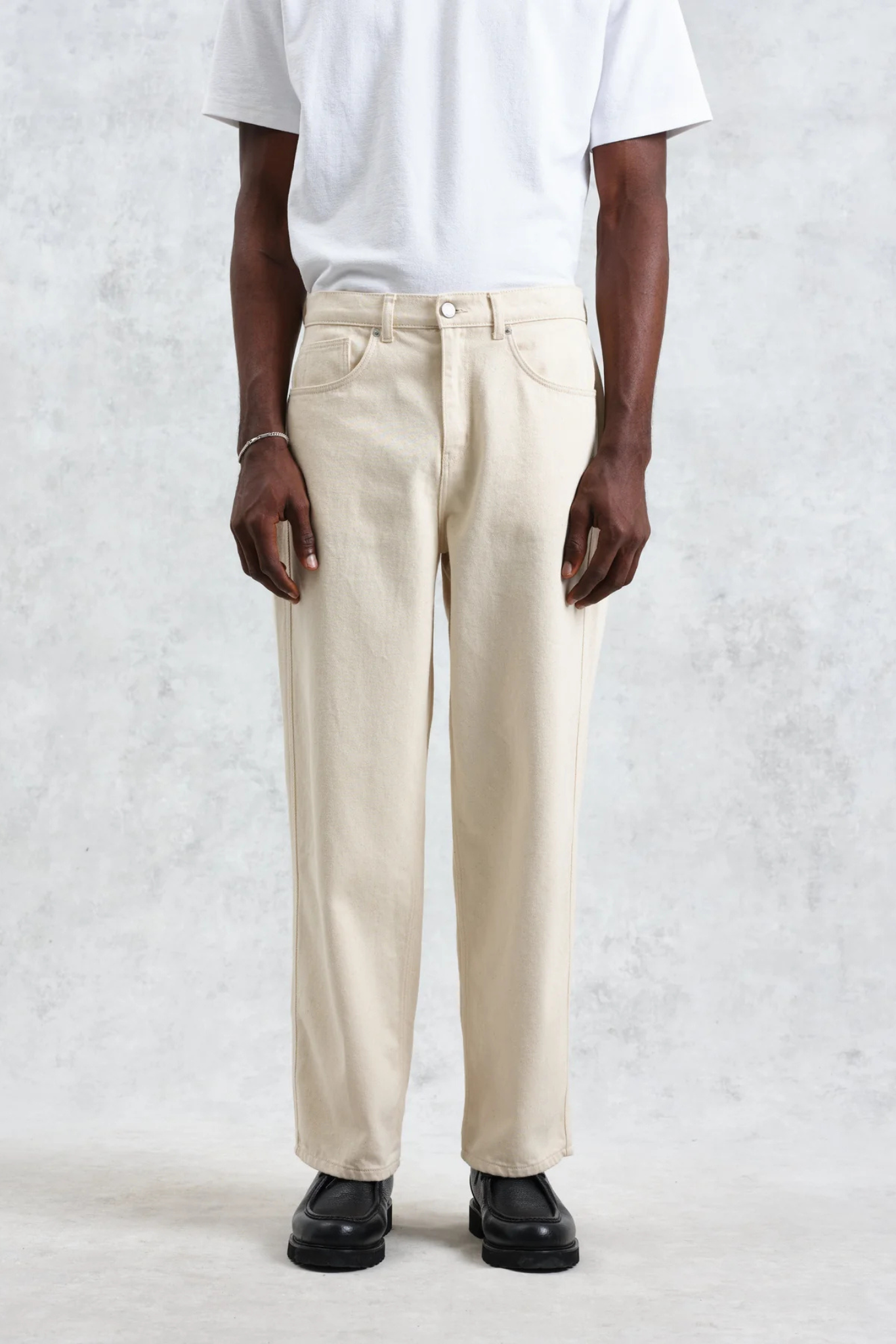 Model wearing the Wax London felix loose fit denim jeans in ecru. Front view