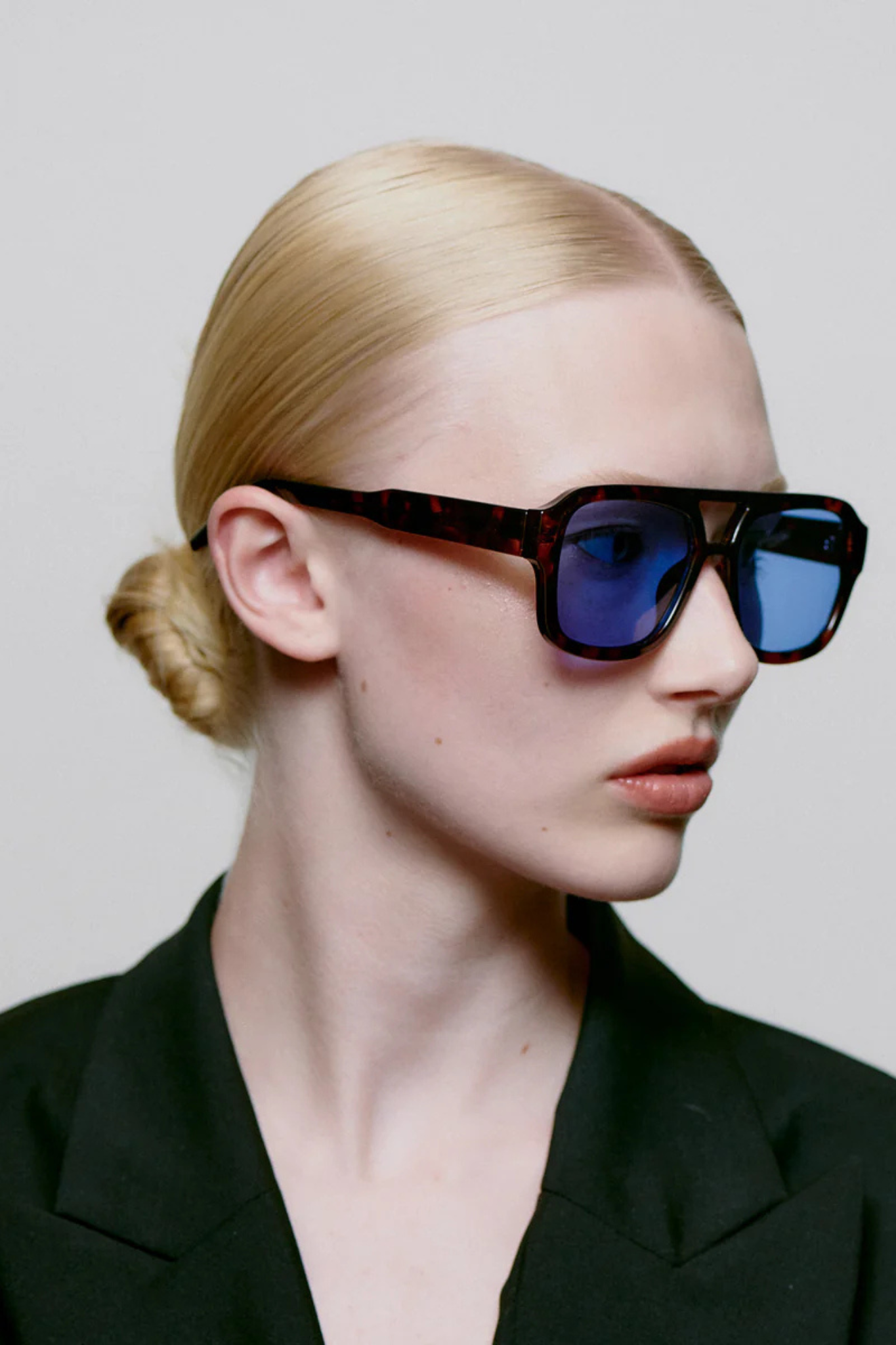 Model wearing the A. Kjaerbede kaya sunglasses in demi tortoise (blue lens). Side view