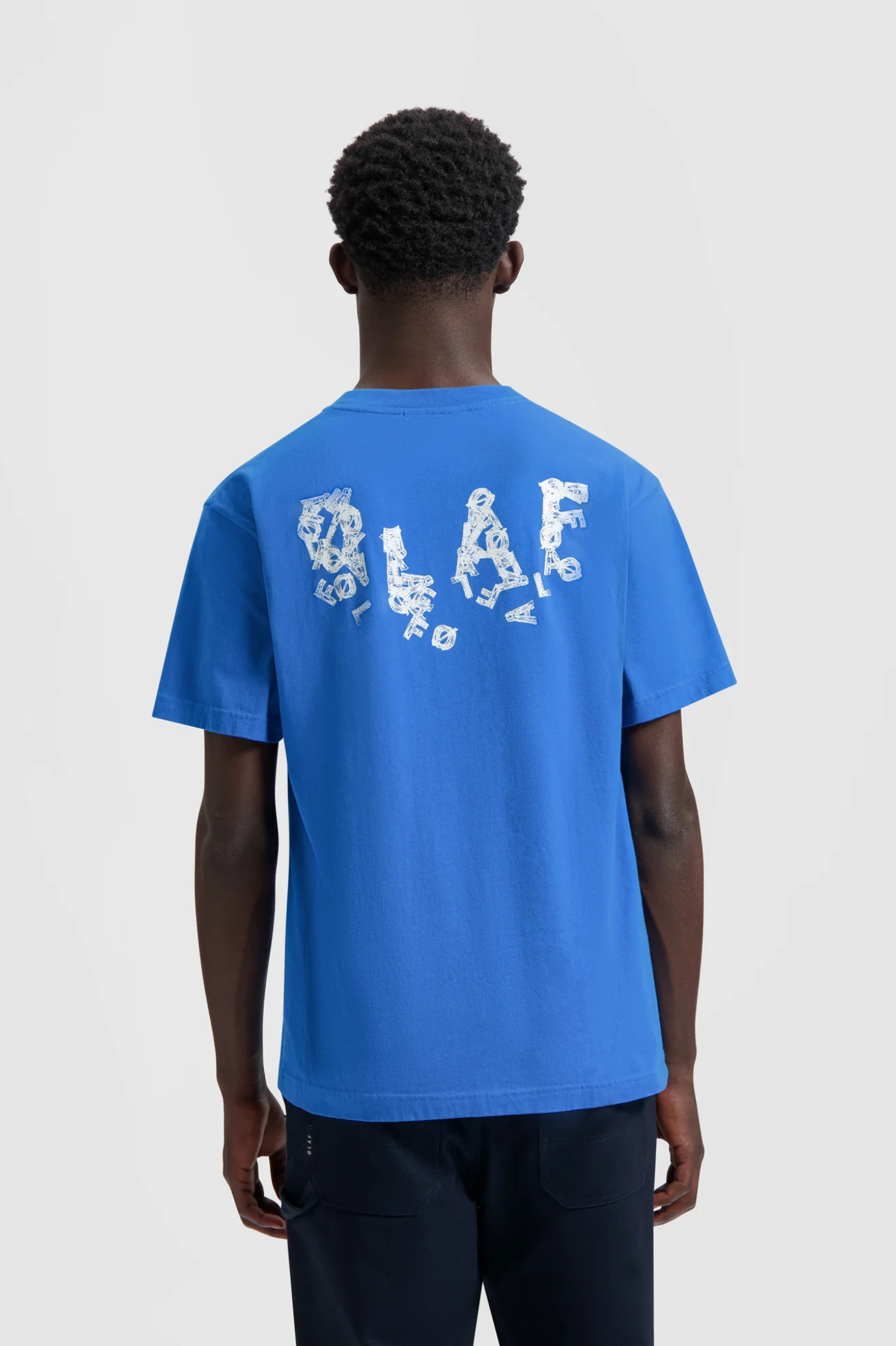 Model wearing the Olaf ink logo t-shirt in blue and logo in white. Back view