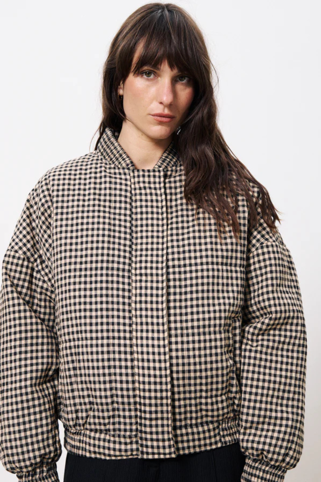 Model wearing the FRNCH padoue coat in checked black and beige. Front view