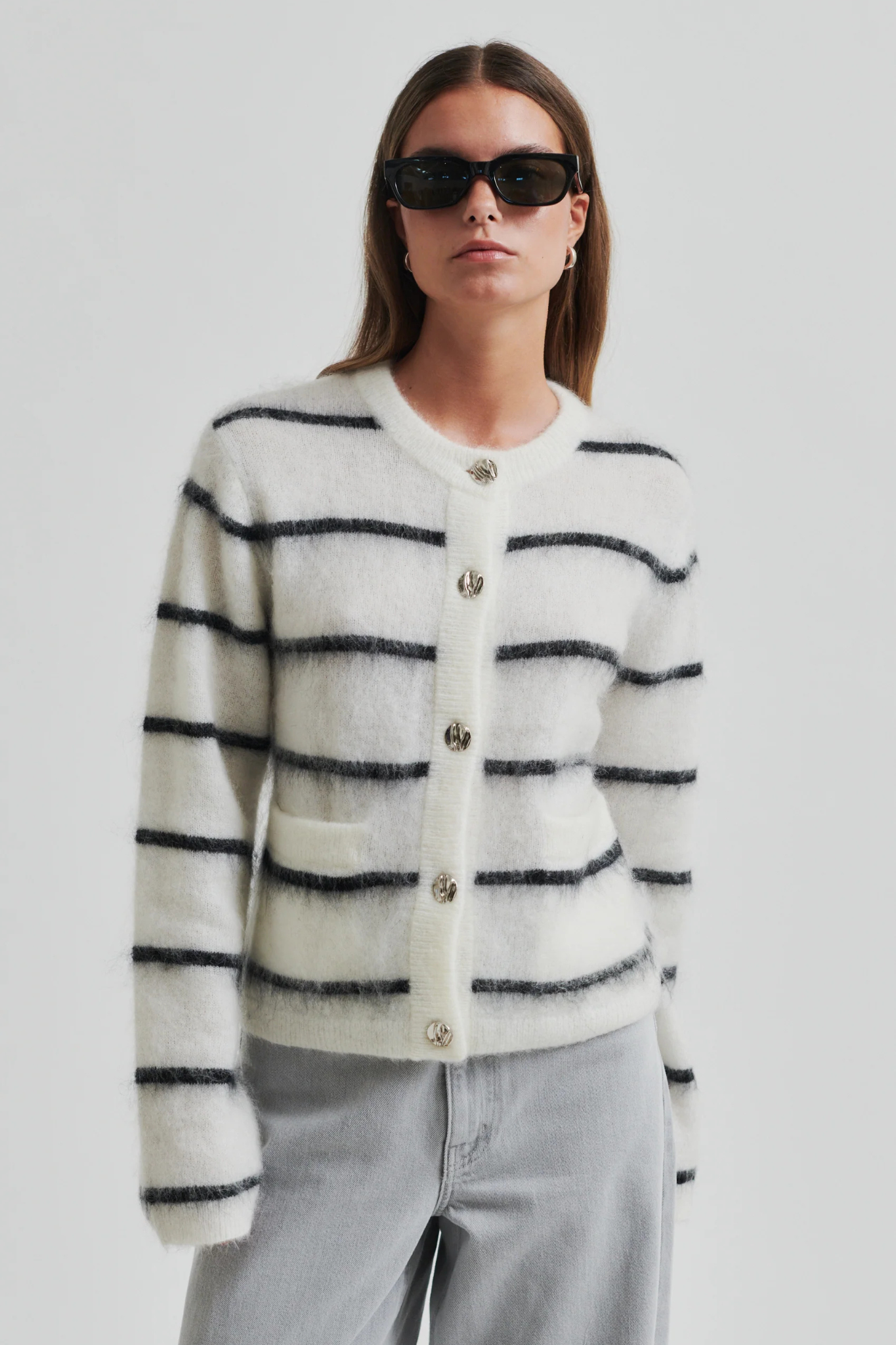 Model wearing the Second Female ovalina knit cardigan in striped white and black. Front view