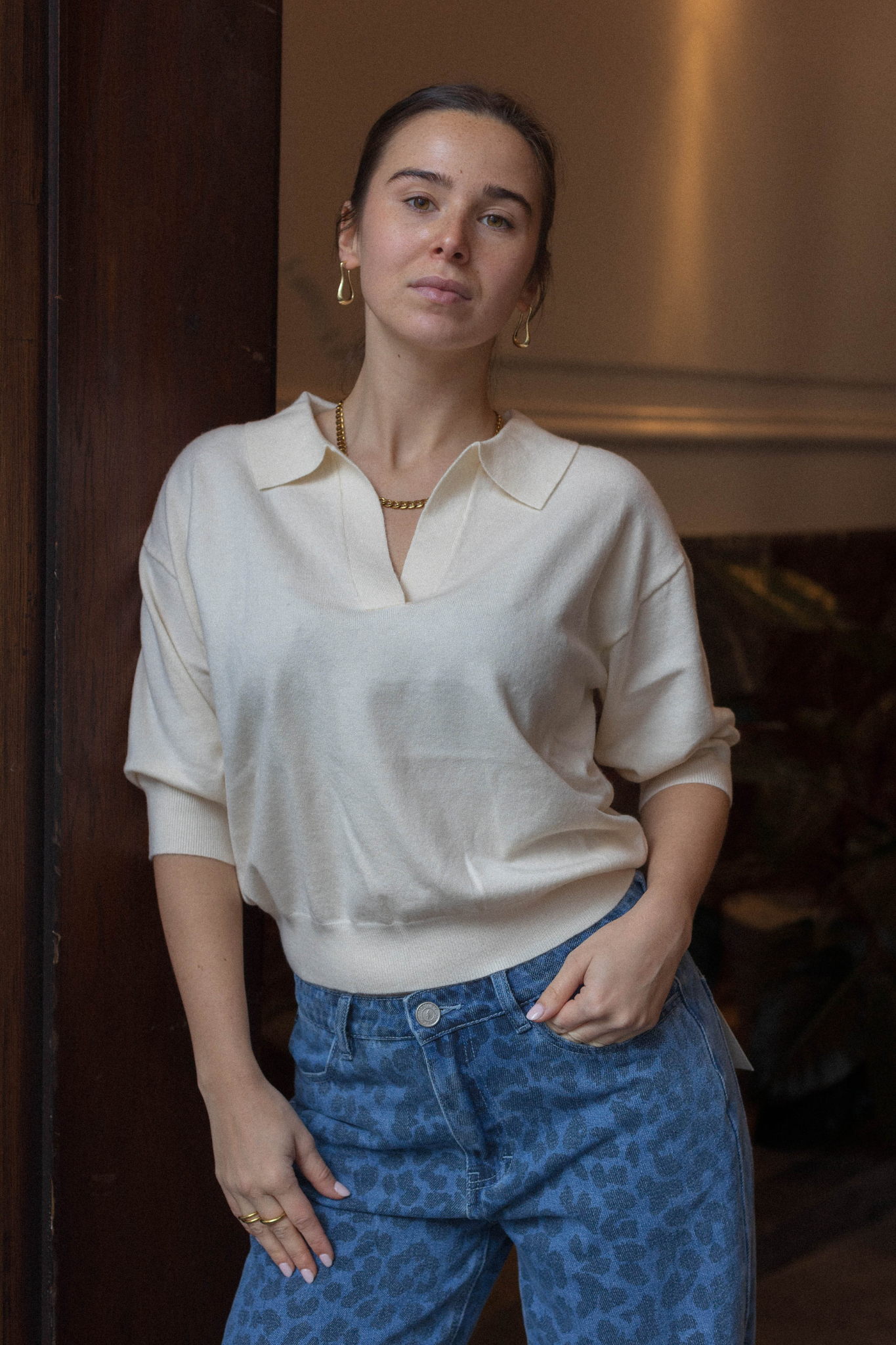 Model wearing the FRNCH plume sweater polo in creme. Front view