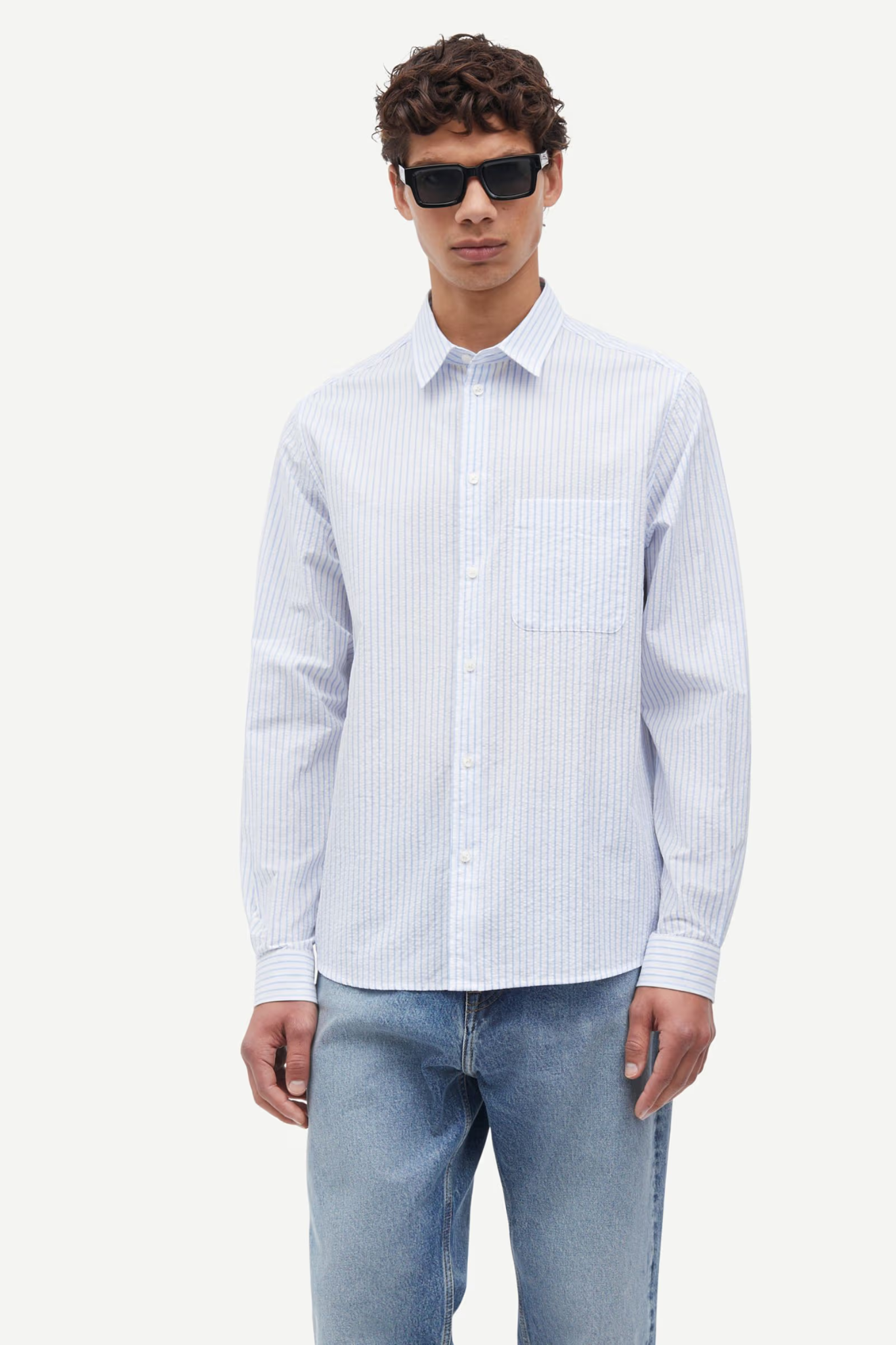 Model wearing the Samsoe Samsoe saryan j shirt in blue and white striped. Front view