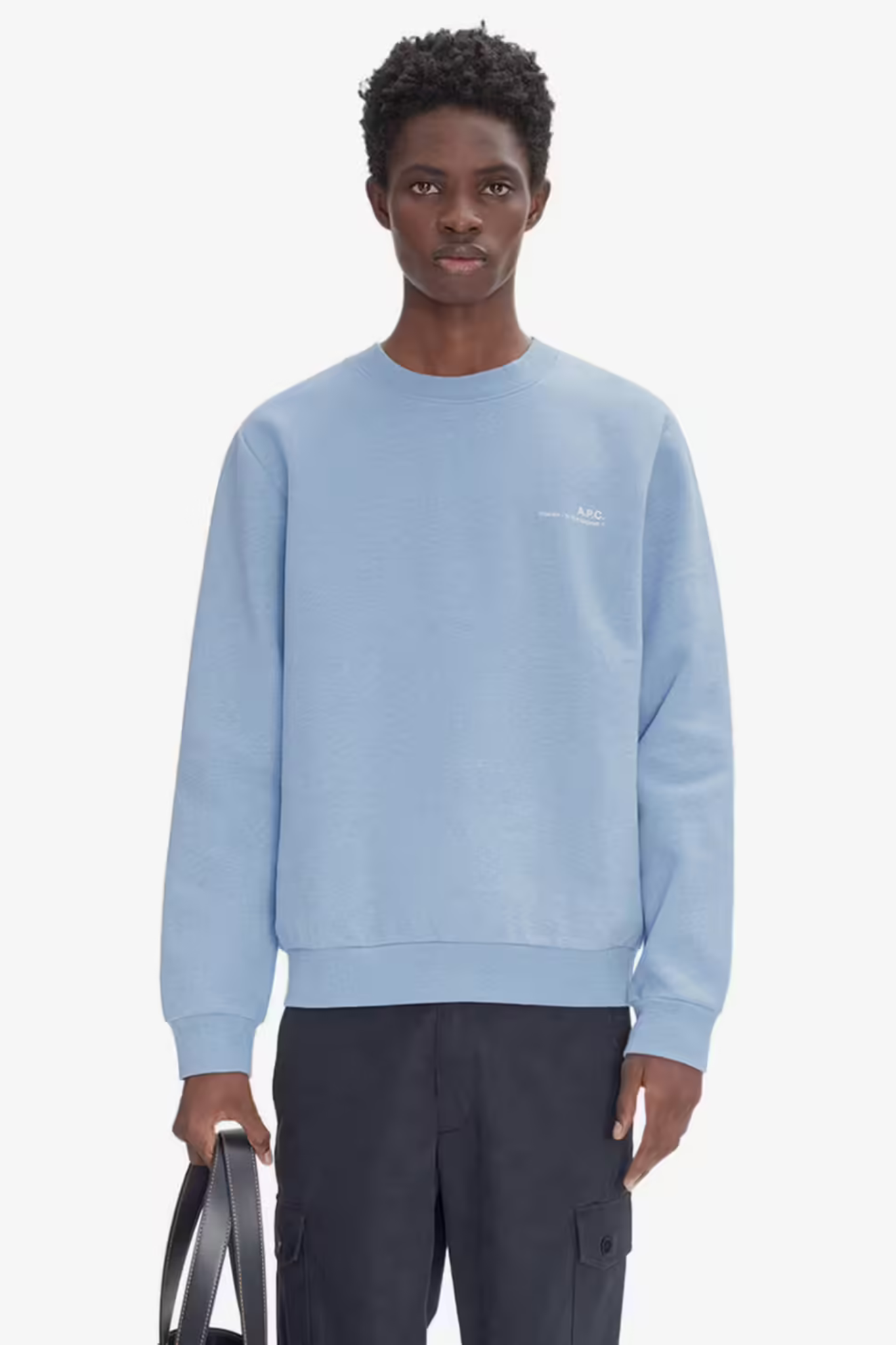 Model wearing the APC overdye sweatshirt in light blue with logo in ecru. Front view