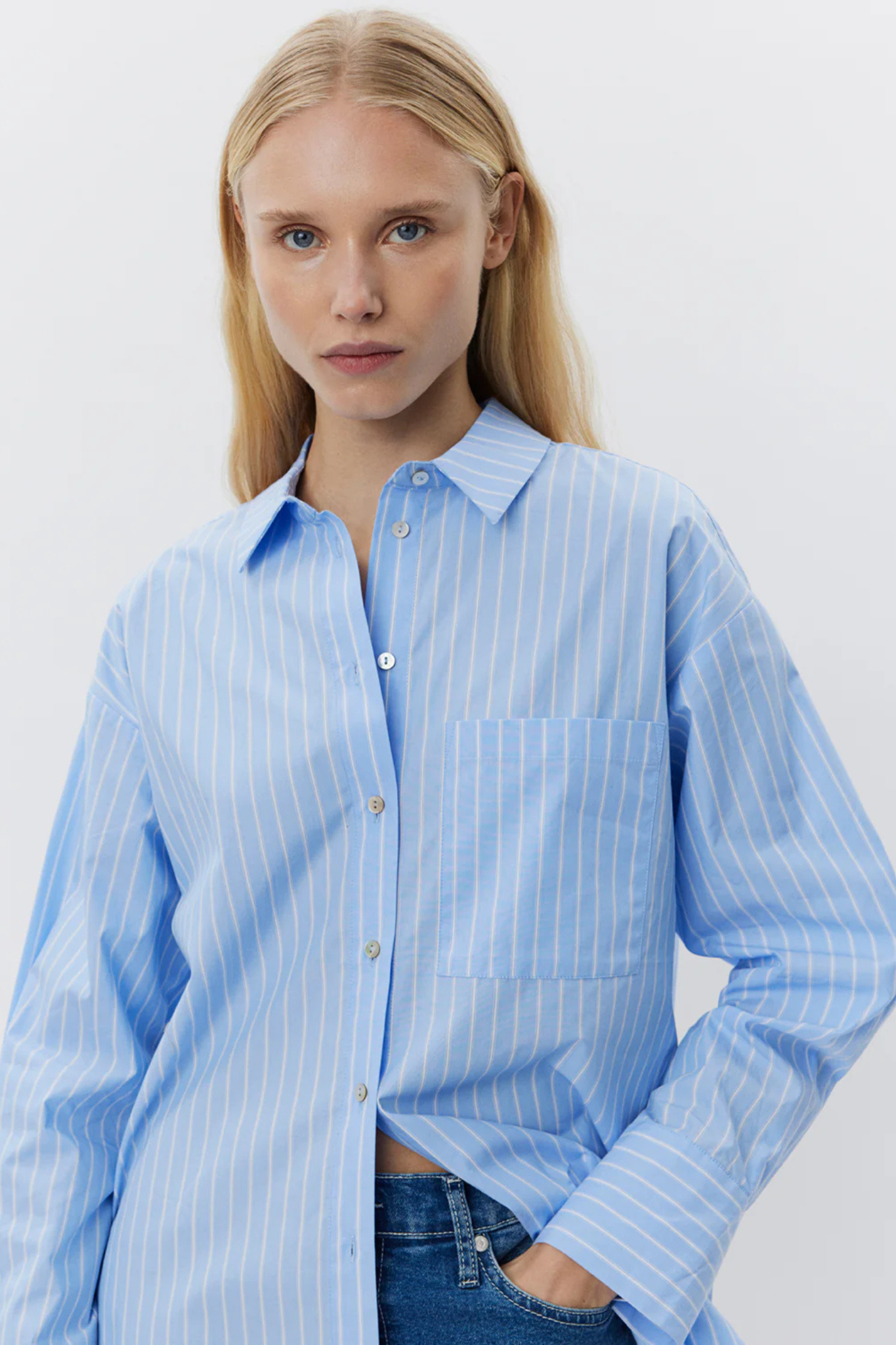 Model wearing the Sofie Schnoor adalene shirt in striped white and blue. Front view