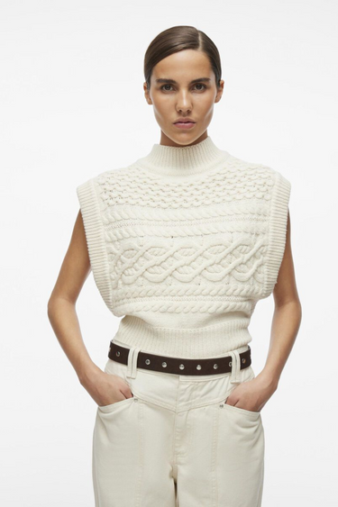 Model wearing the Rouge Edit white sleeveless knitted vest. Front view