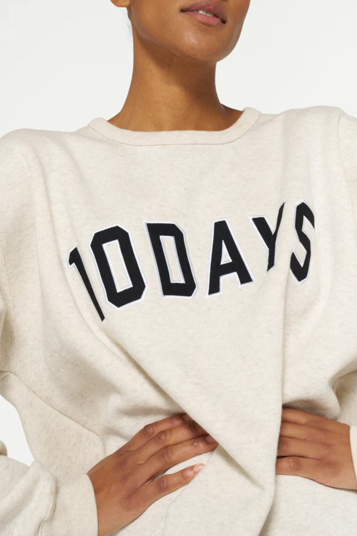 Model wearing the 10DAYS statement sweater in soft white melee. Front view