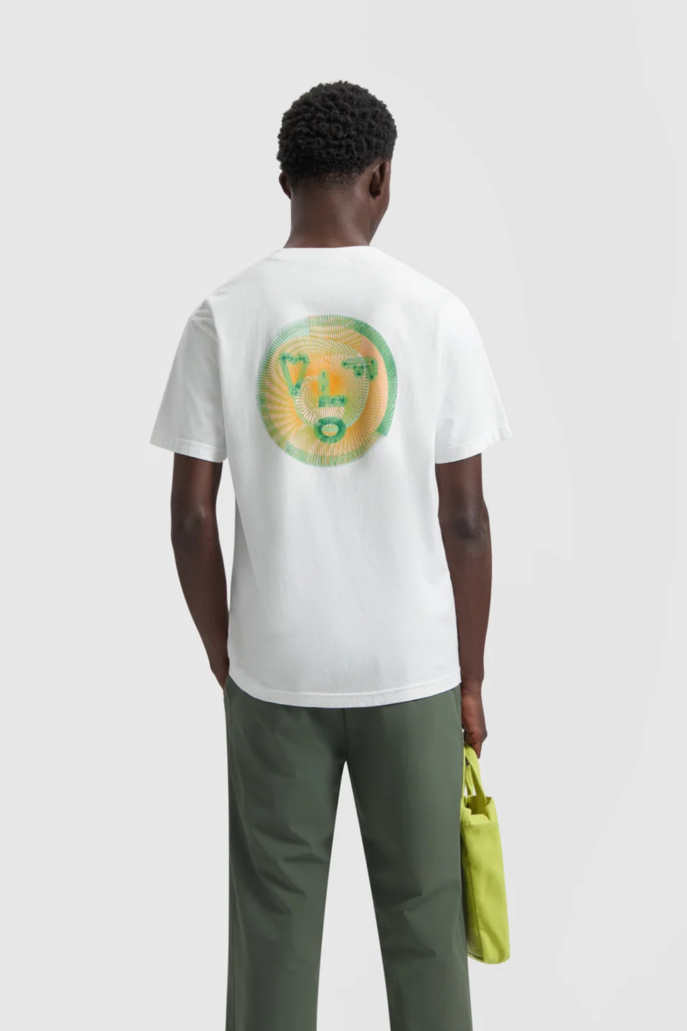 Model wearing the Olaf spiral face t-shirt in white and face in green. Back view