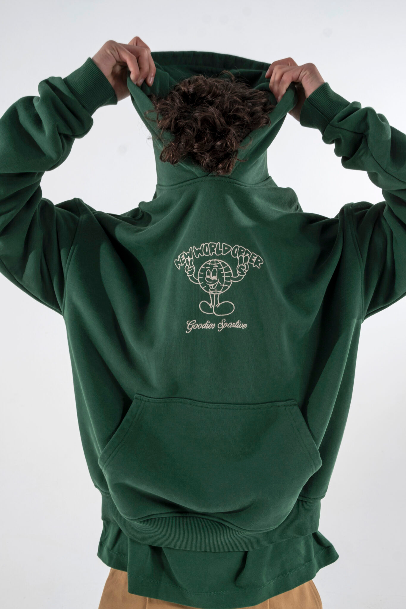 Model wearing the Goodies Sportive new world hoodie in green and graphic in white. Front view