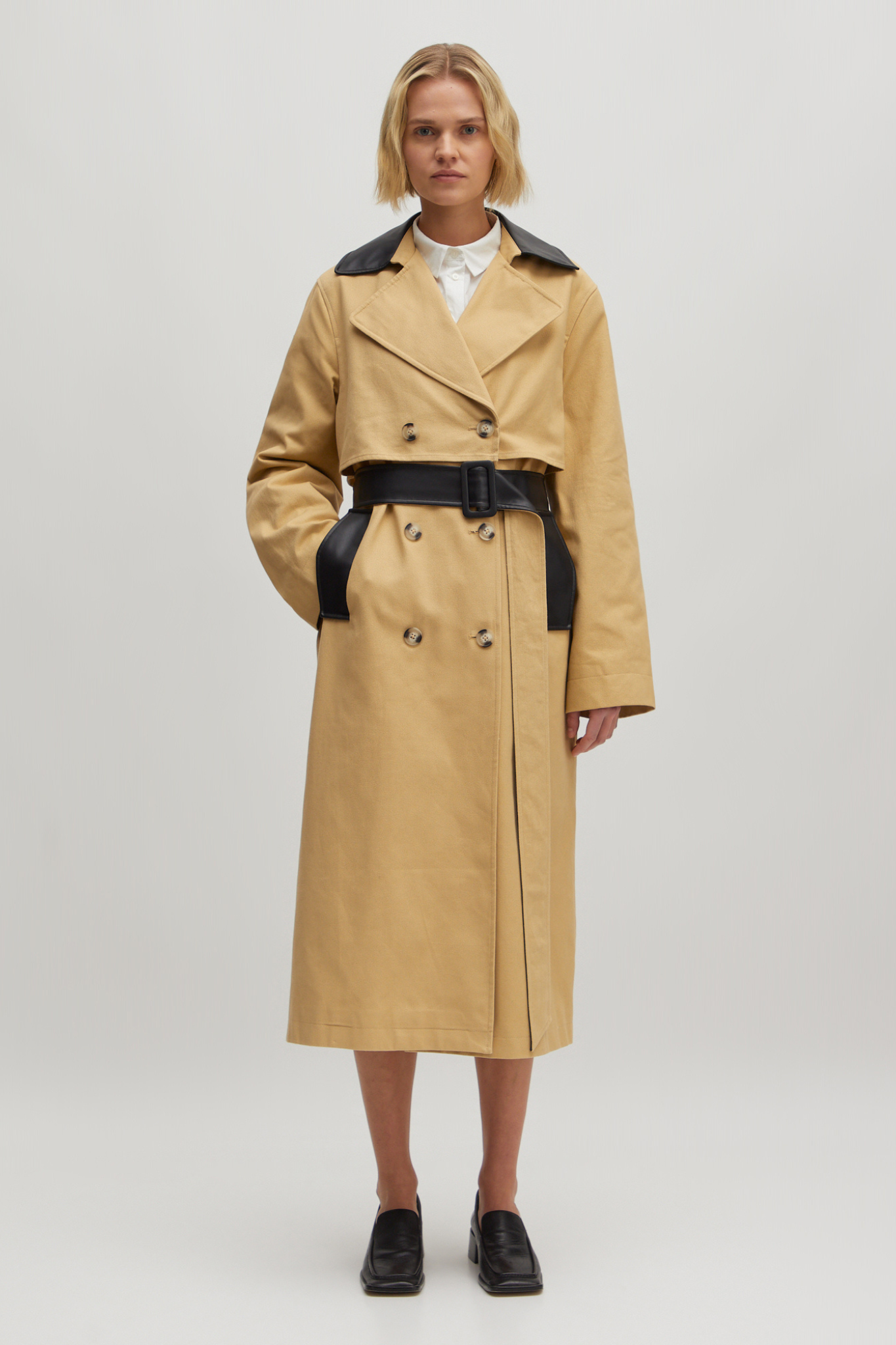 Model wearing the Edited aiko trenchcoat in beige and black. Front view