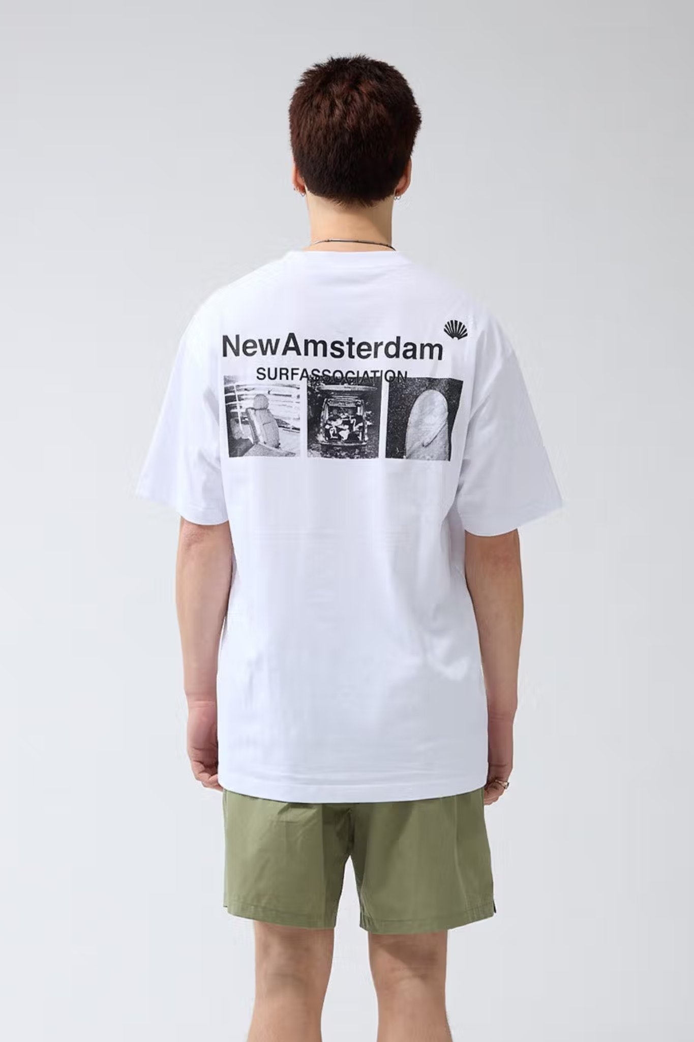 Model wearing the New Amsterdam white t-shirt with photo print on the back and logo in black. Back view