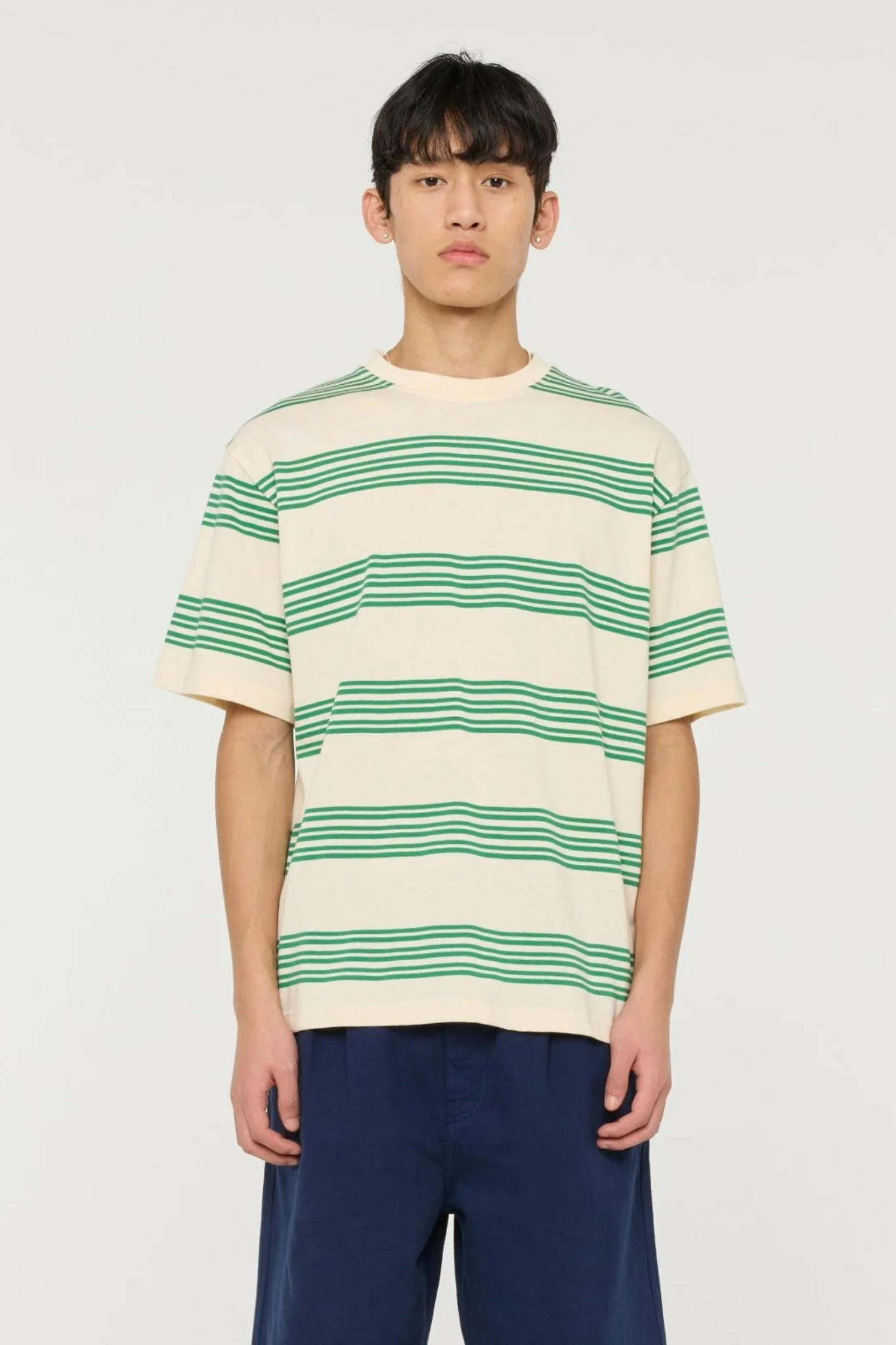 Model wearing the Castart haruto striped t-shirt in green and ecru. Front view