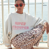 Model wearing the By-Bar grey bibi trouper sweater with letters in pink. Front view