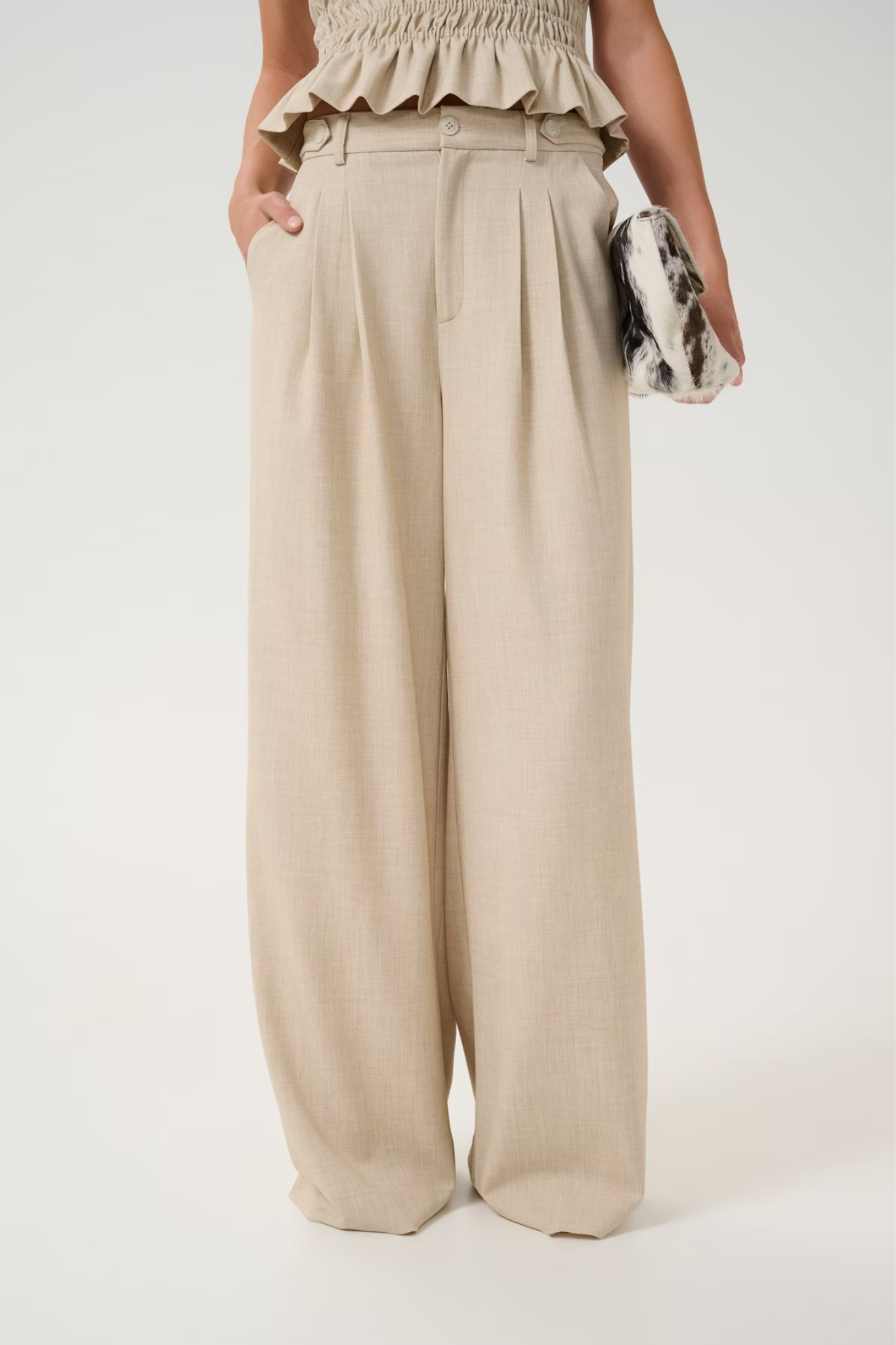 Model wearing the Gestuz decy pants in light sand melange. Front view