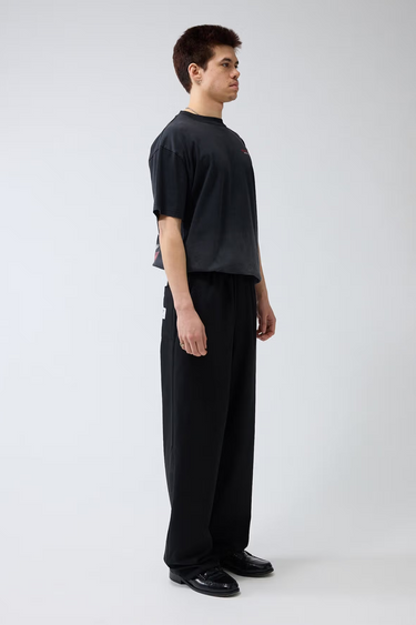 Model wearing the black New Amsterdam wool trousers. Side view