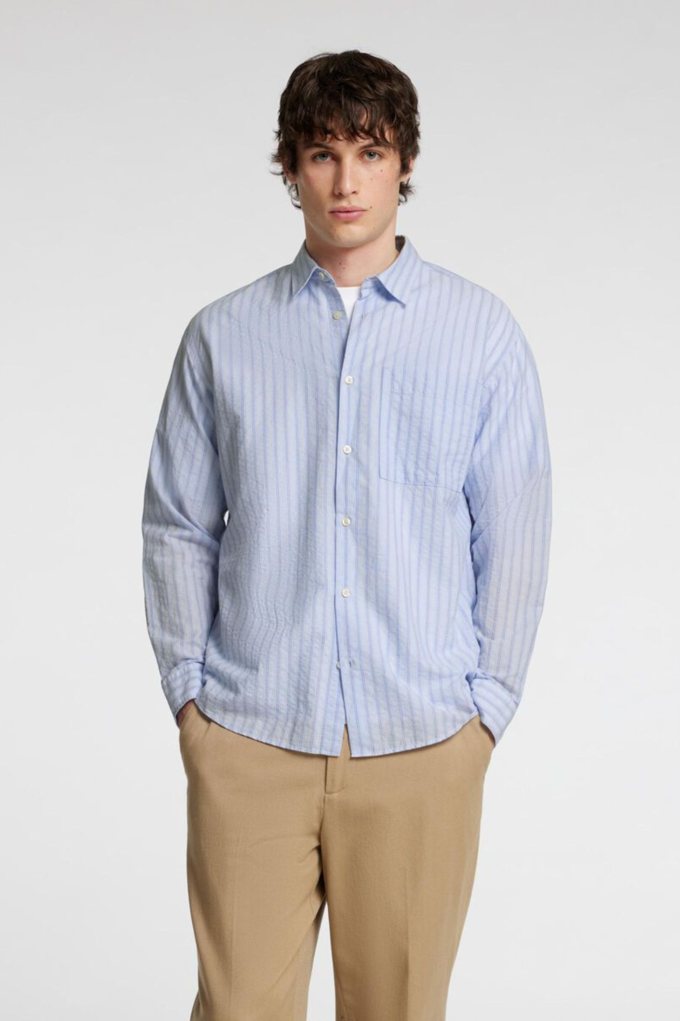 Model wearing the Selected Homme relax wilfred seersucker shirt in blue stripe. Front view