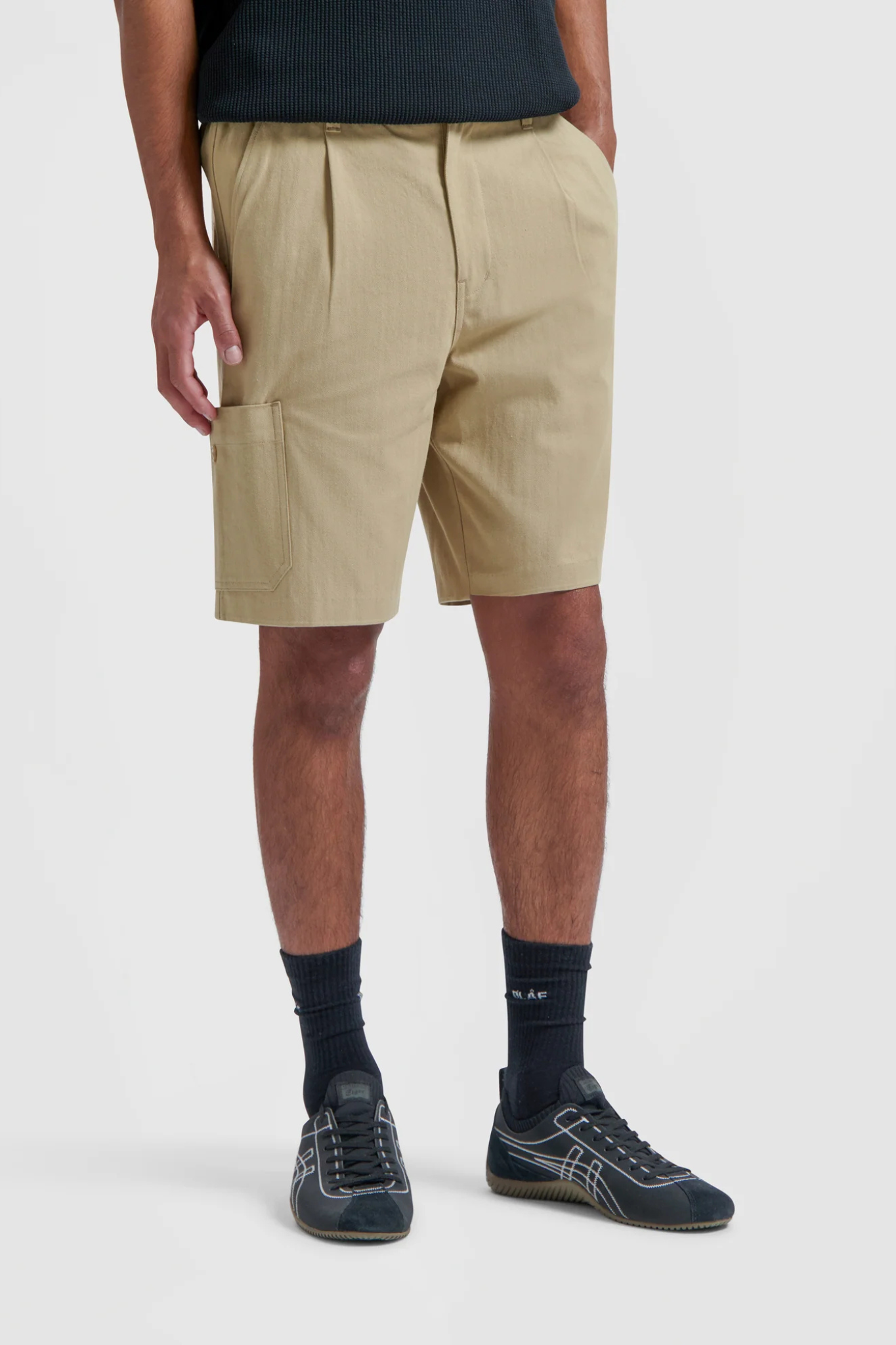 Model wearing the Olaf utility workwear shorts in beige khaki. Front view