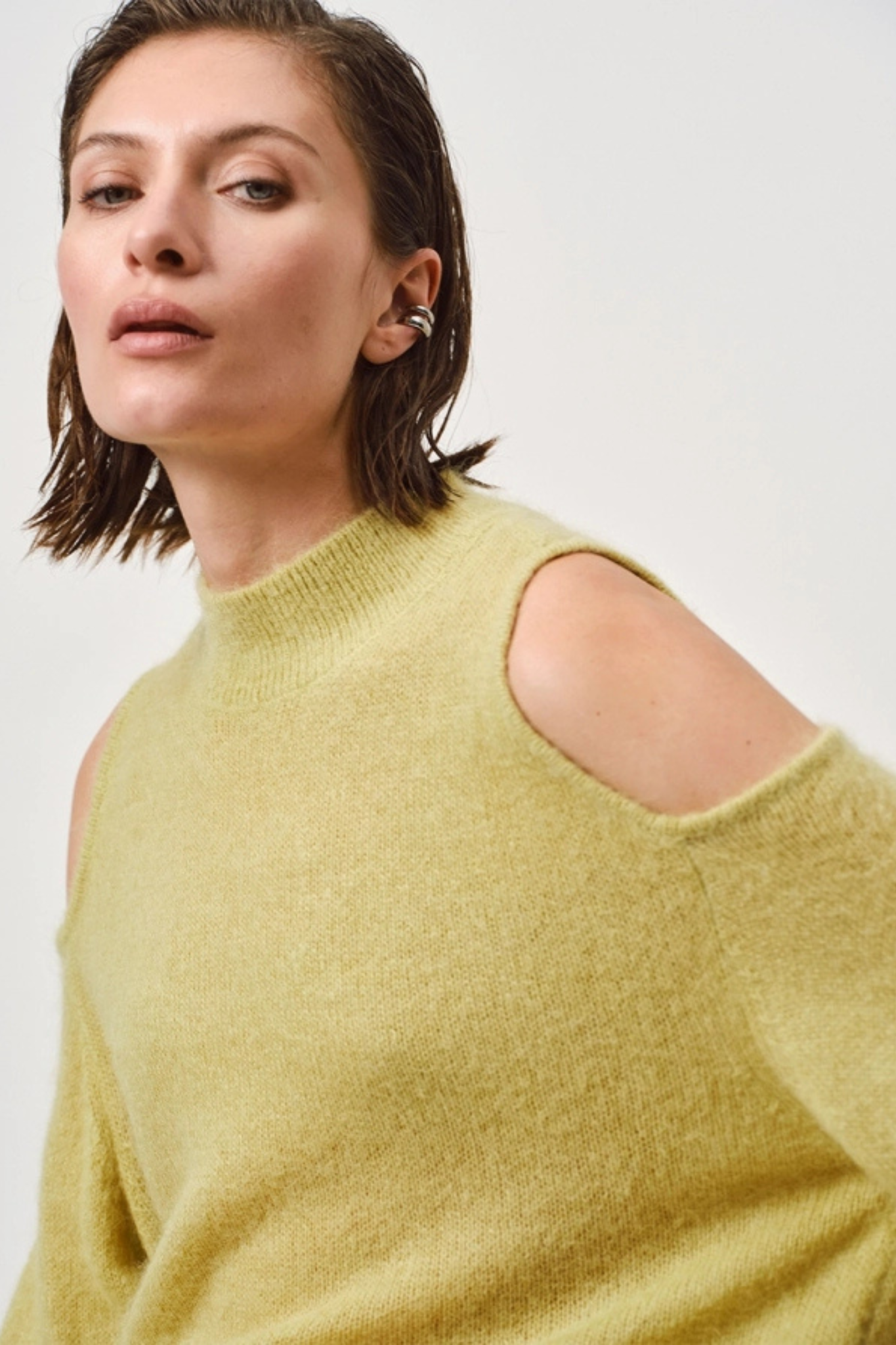 Model wearing the Dante6 aviel open shoulder sweater in lemon grass. Side view