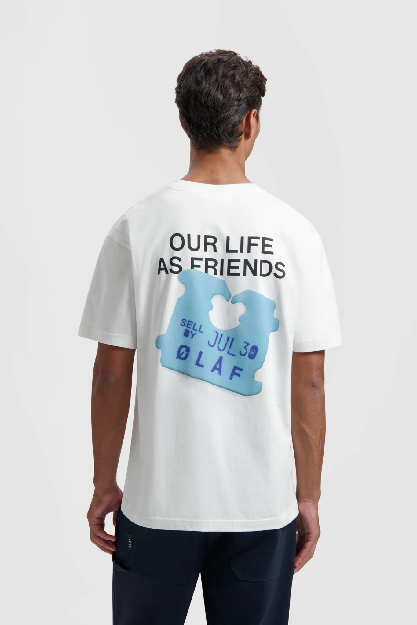 Model wearing the Olaf friends clip t-shirt in white and clip in blue. Back view