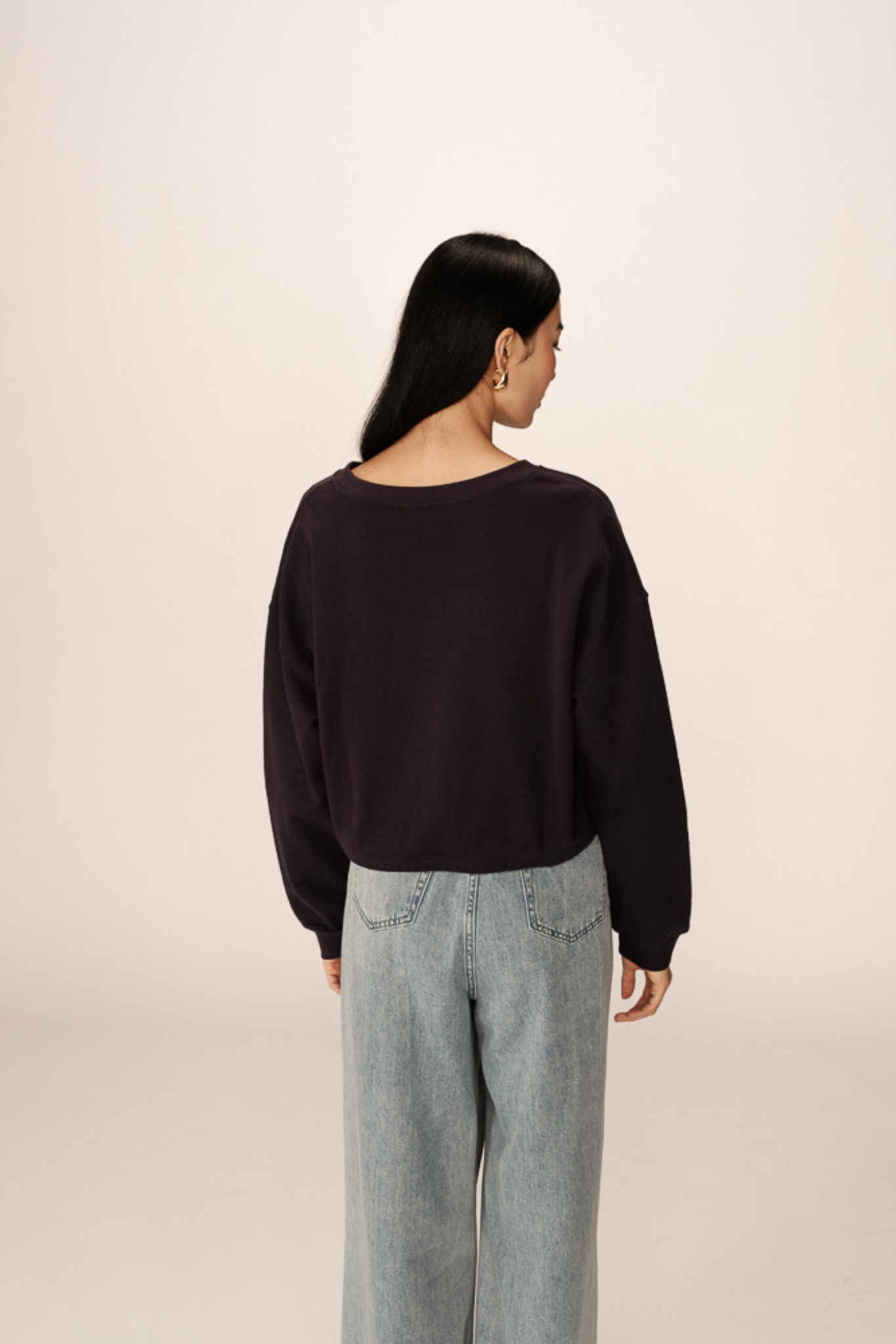 Model wearing the Grace & Mila podium sweatshirt in marine. Back view