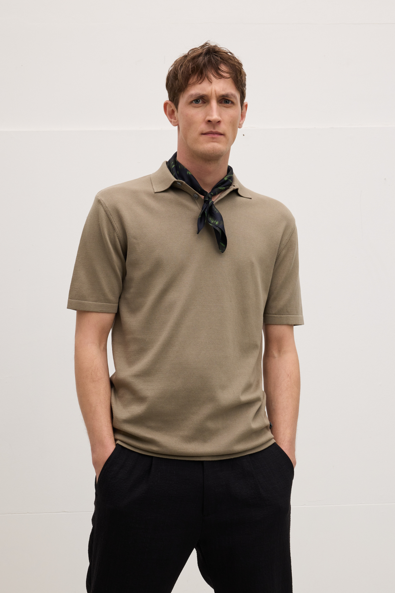 Model wearing the Goodpeople plan polo shirt in dark taupe. Front view