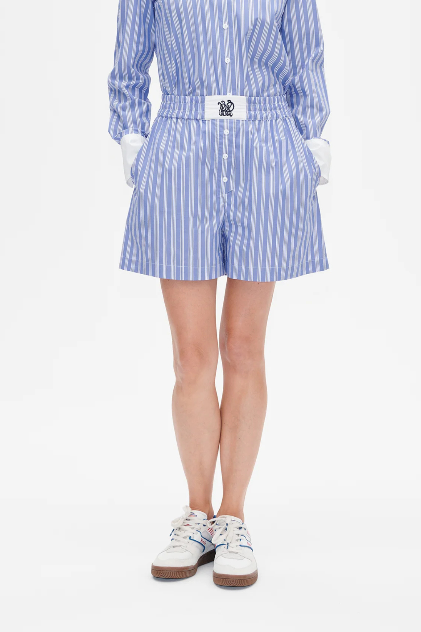 Model wearing the Baum Und Pferdgarten natie short in blue and white striped. Front view