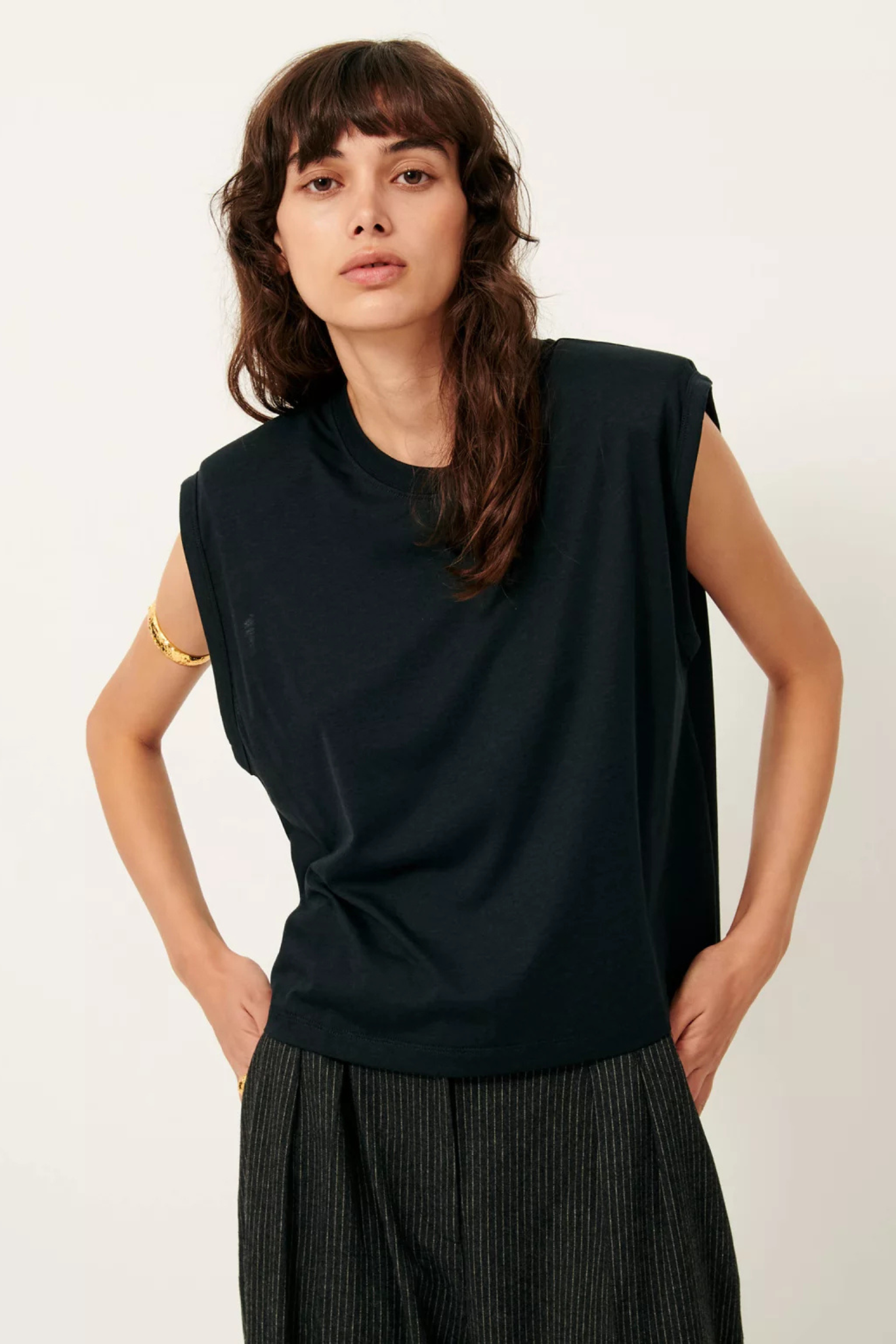 Model wearing the Sessun dee shoulder pad sleeveless t-shirt in black. Front view