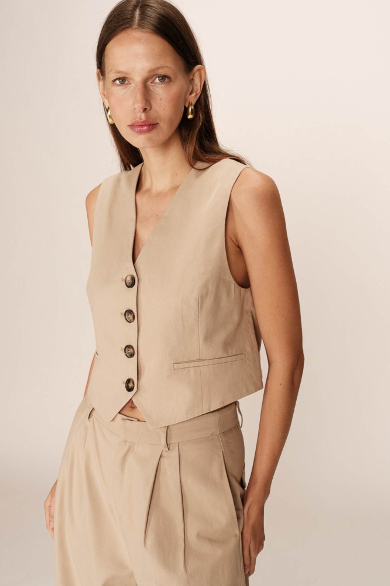 Model wearing the Grace & Milla penn waistcoat in beige. Front view