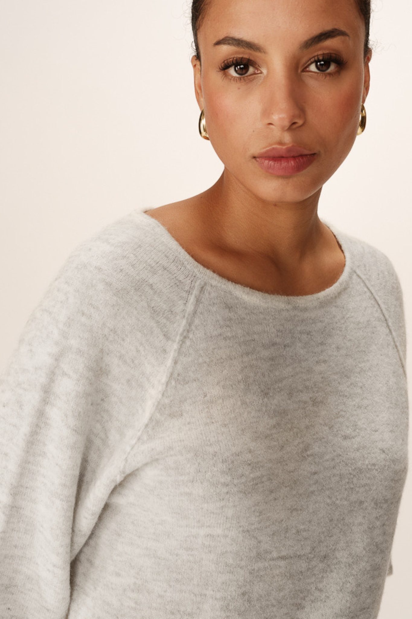 Model wearing the Grace & Mila paco sweater in grey. Close front view