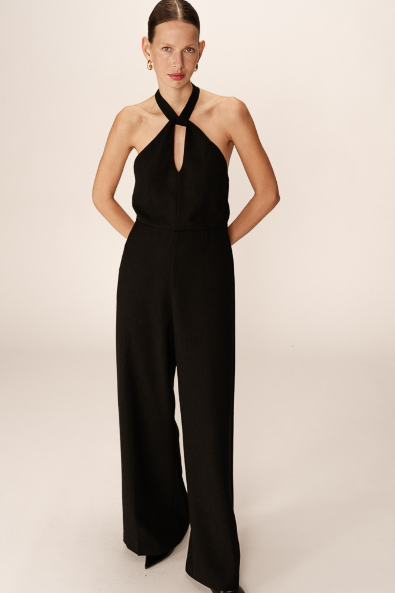 Model wearing the Grace & Mila philomene jumpsuit with open back in black. Front view