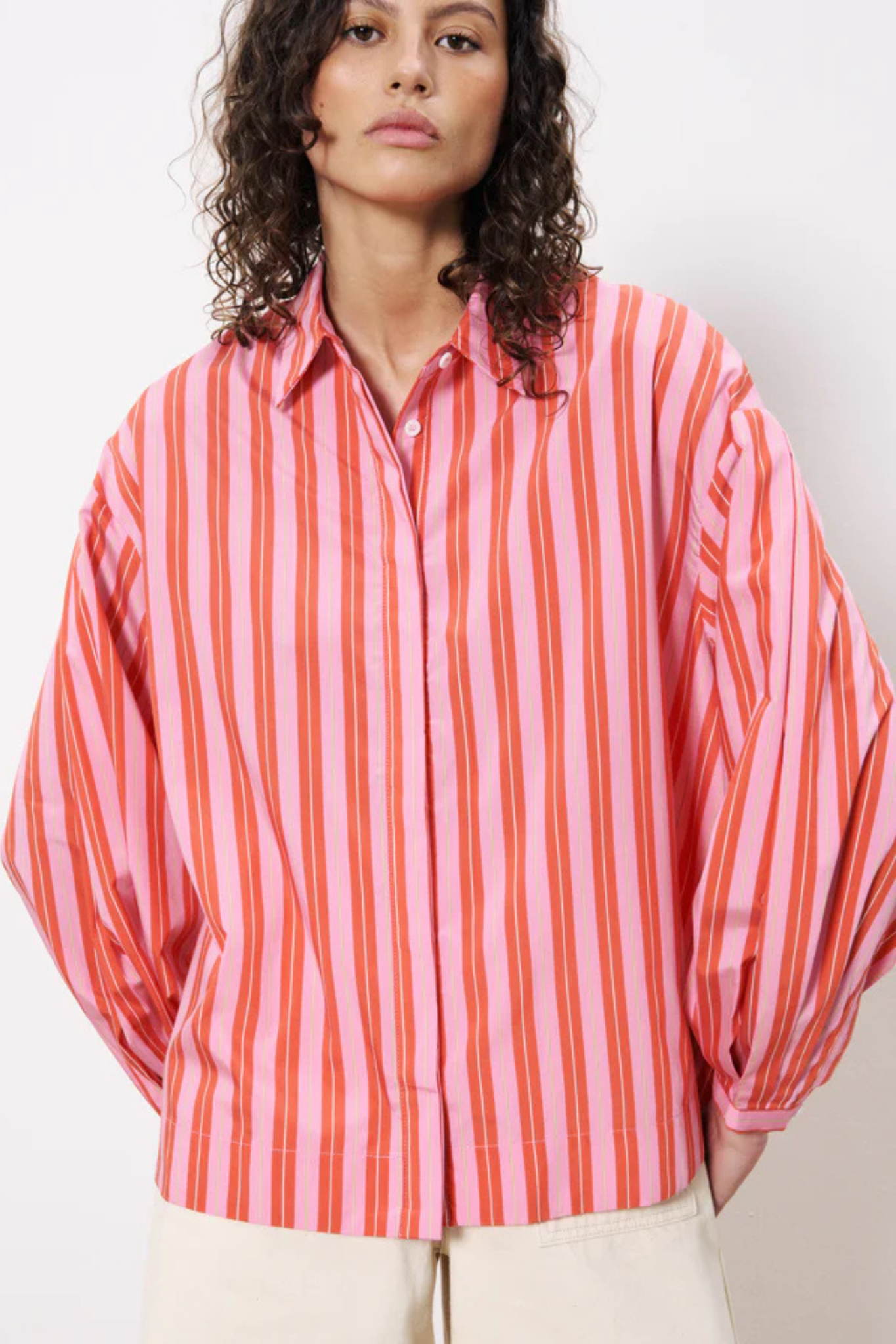 Model wearing the FRNCH catheline shirt in pink and orange striped. Front view