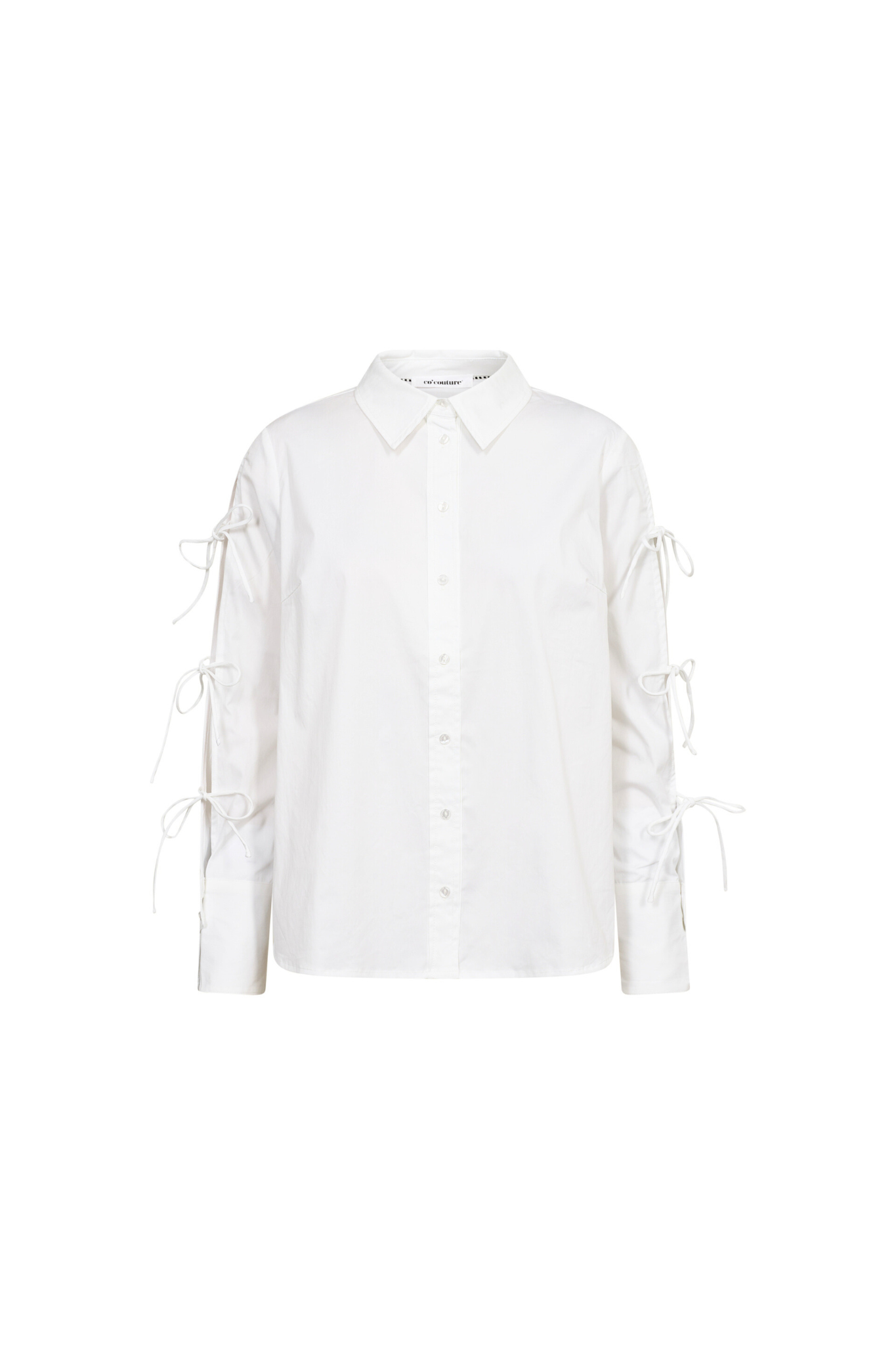 Co'Couture white shirt with bows on sleeve. Front flatlay view