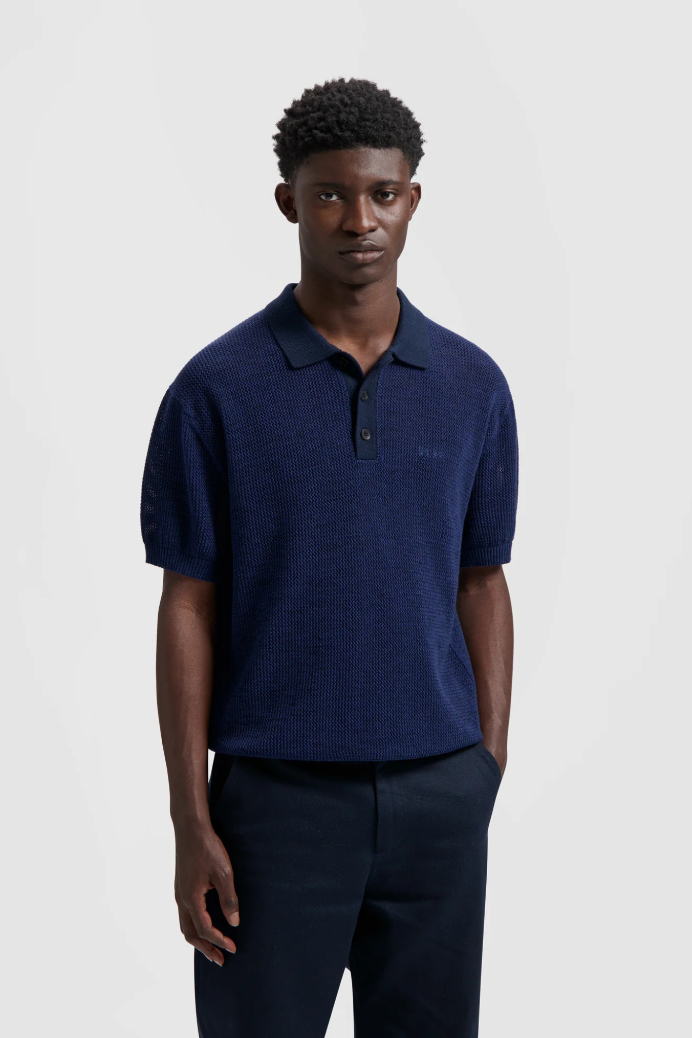 Model wearing the Olaf polo knit in dark navy. Front view