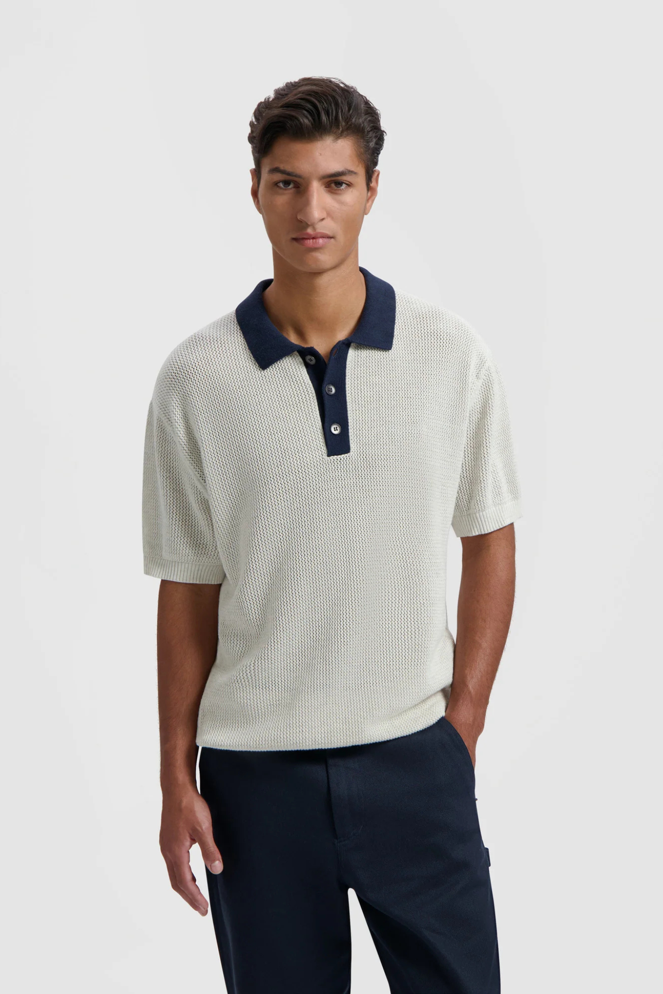 Model wearing the Olaf varsity polo knit in off white and dark blue. Front view