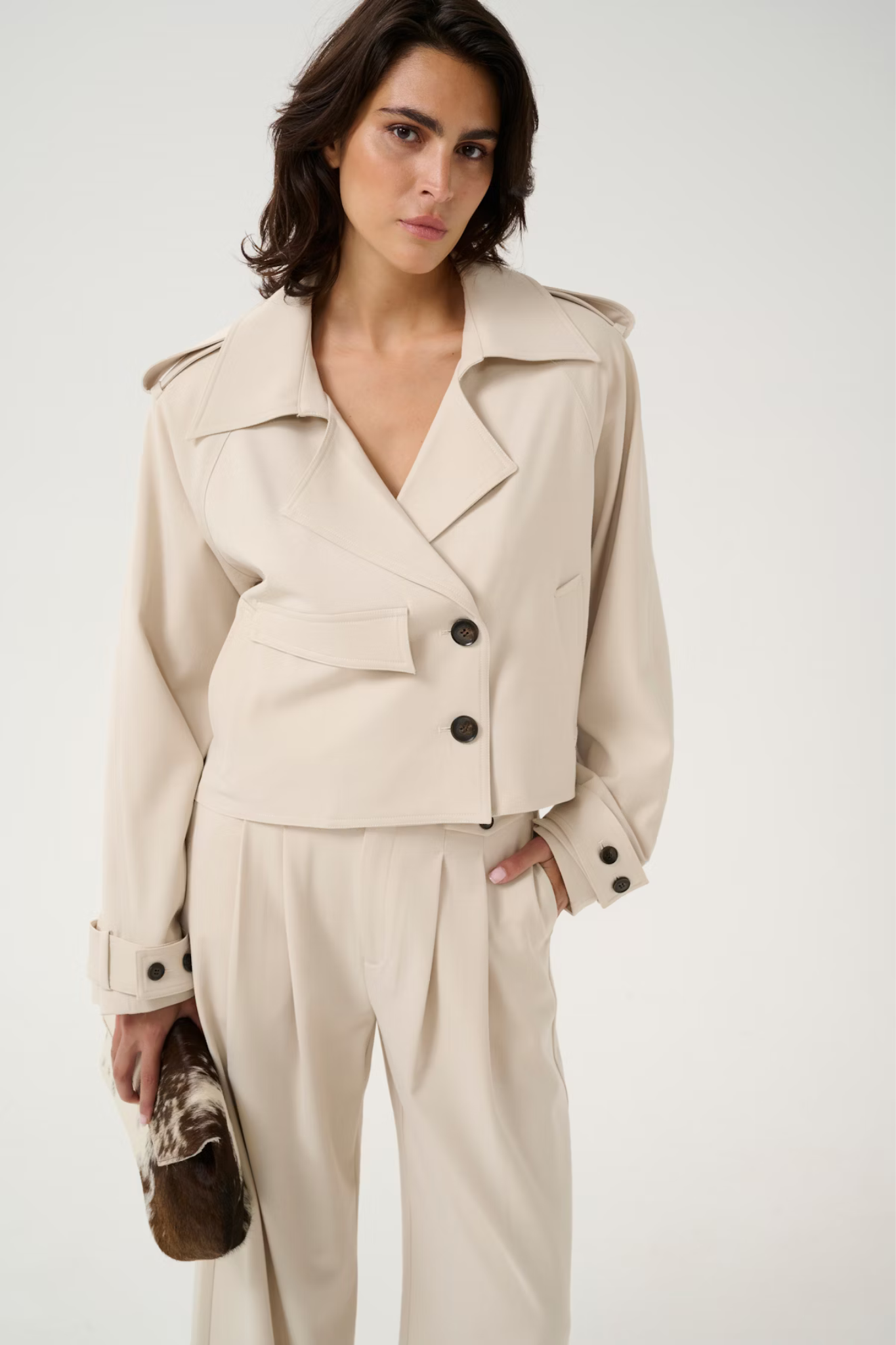 Model wearing the Gestuz zedina short jacket in beige. Front view