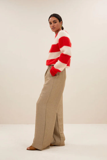 Model wearing the By-Bar Sian striped pullover in red and white. Side view