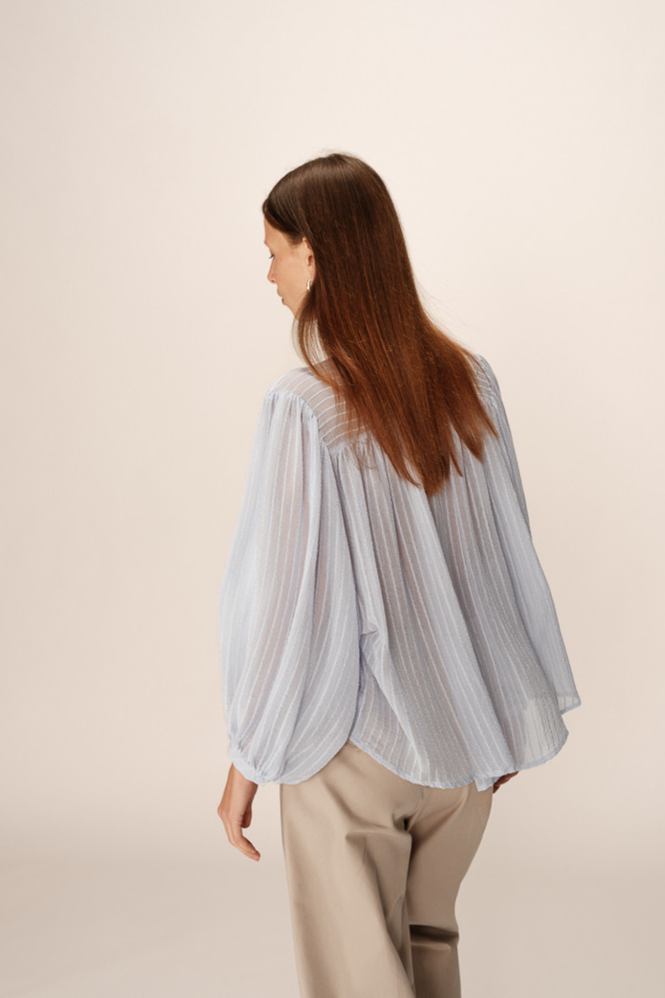 Model wearing the Grace & Mila poesie blouse in blue. Back view