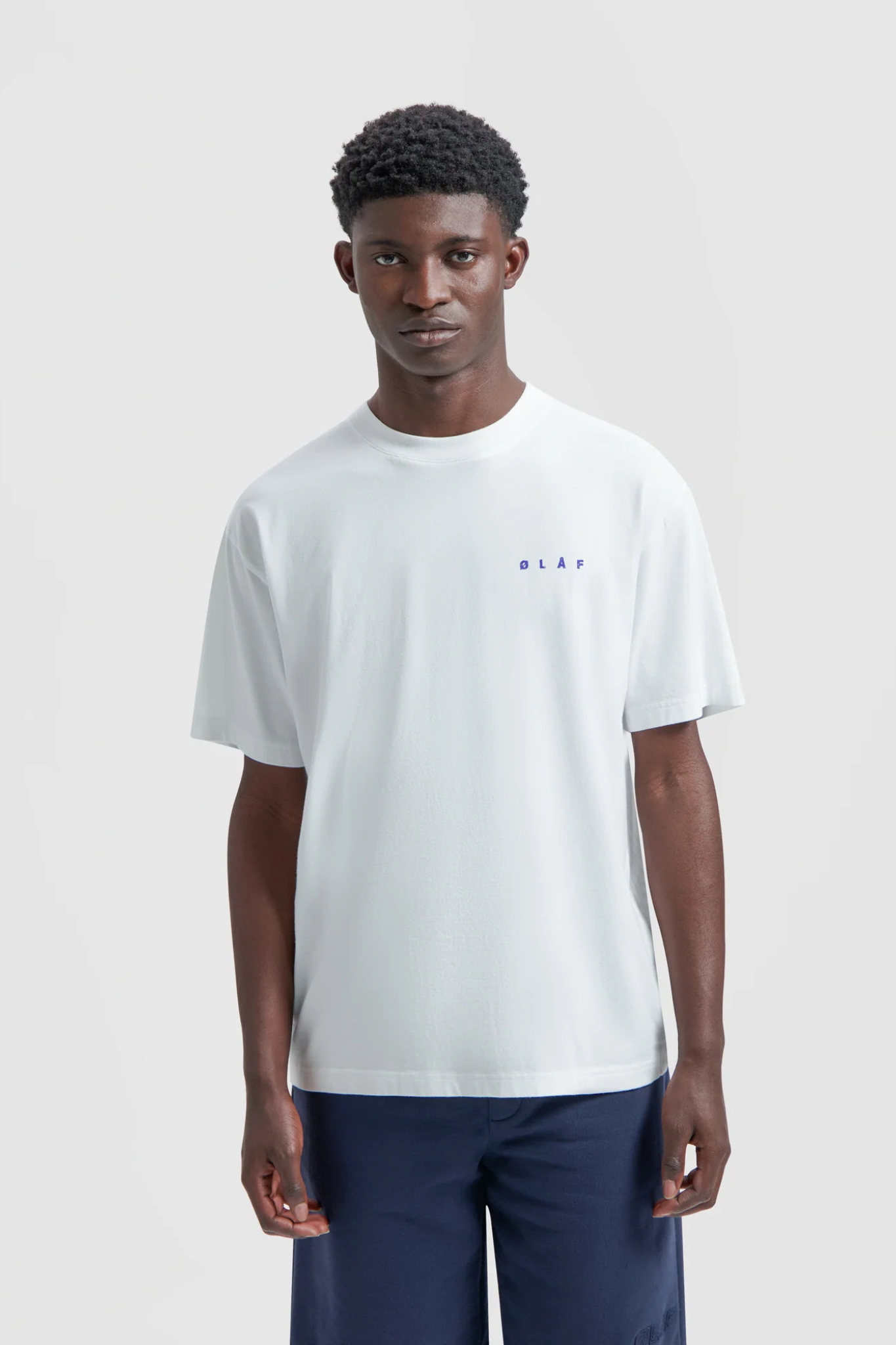 Model wearing the Olaf ink logo t-shirt in white and logo in blue. Front view