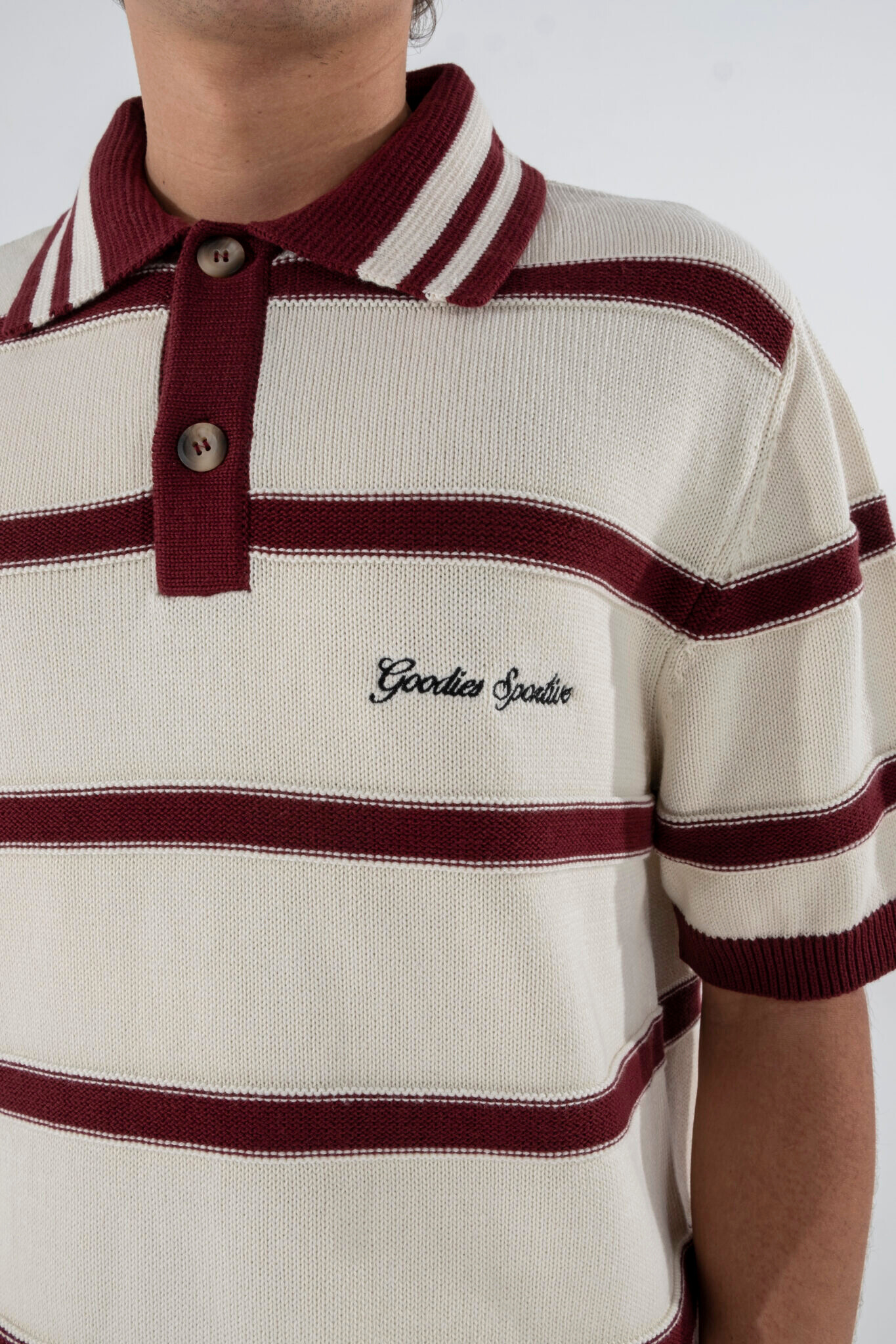 Model wearing Goodies Sportive plum polo shirt in ecru and burgundy. Close front view