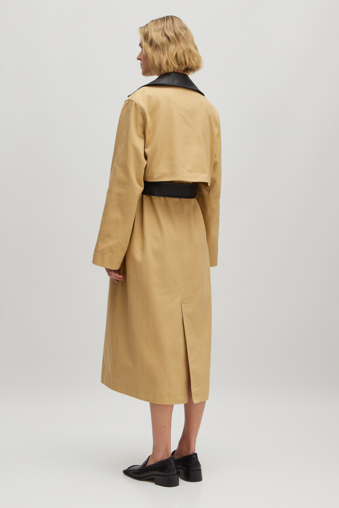 Model wearing the Edited aiko trenchcoat in beige and black. Back view