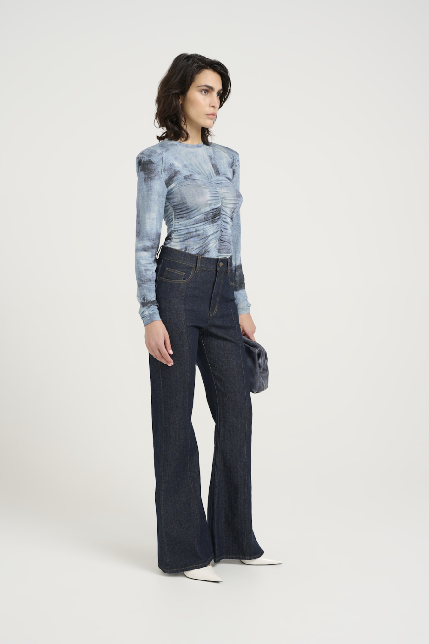 Model wearing the Gestuz areen blouse in blue denim. Side view