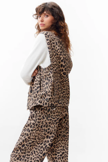 Model wearing the Catwalk Junkie sleeveless leopard denim jacket. Side view