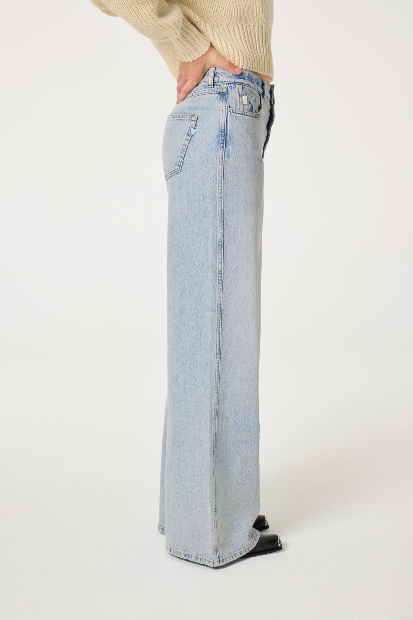 Model wearing the Fabienne Chapot alex wide leg jeans in faded light blue. Side view