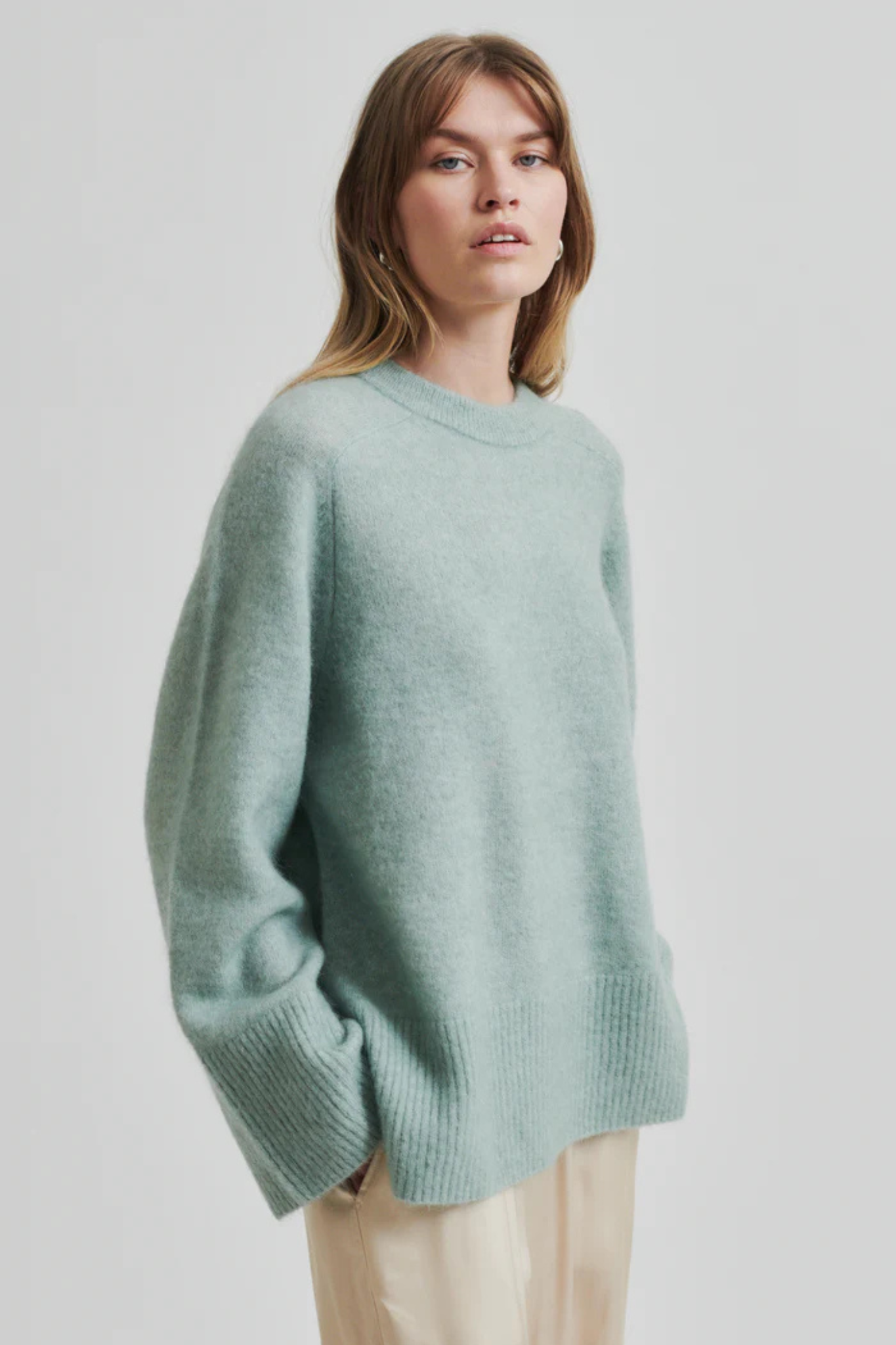 Model wearing the Second Female brookline raglan o-neck knit in green. Front view