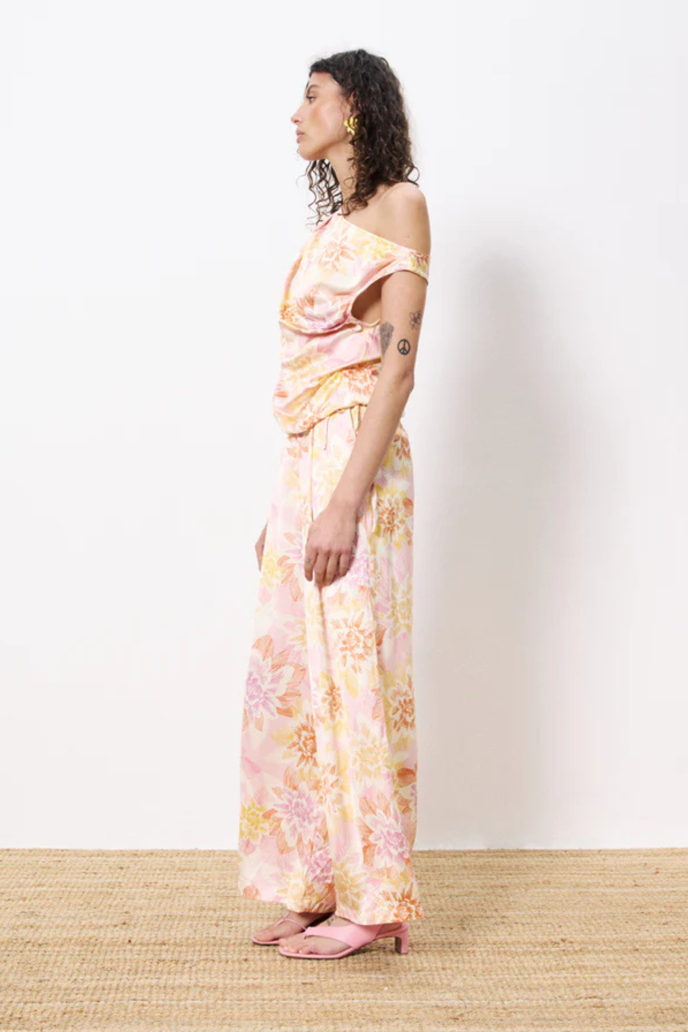 Model wearing the FRNCH philo pants in flower pattern. Side view