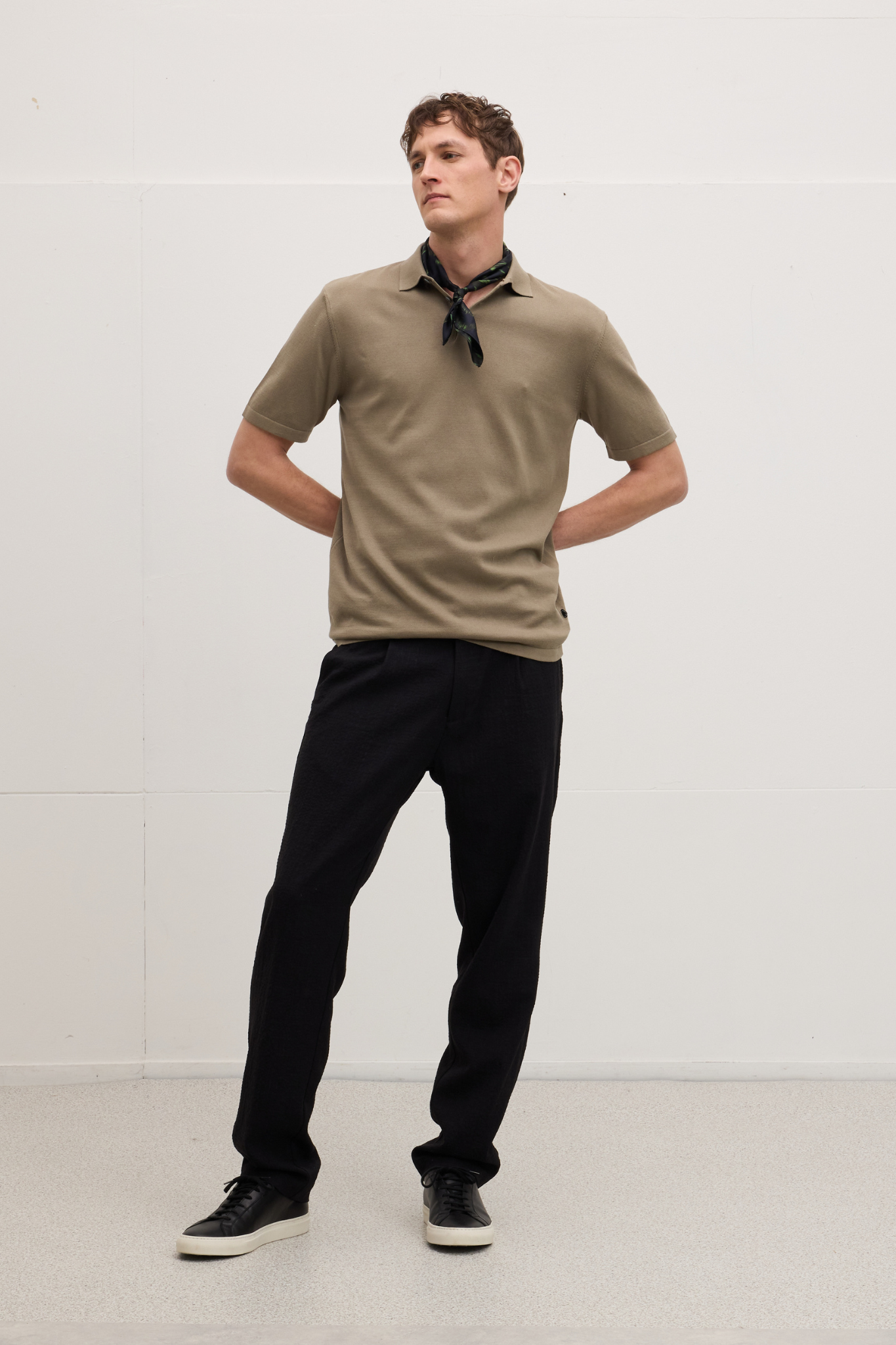 Model wearing the Goodpeople plan polo shirt in dark taupe. Front view