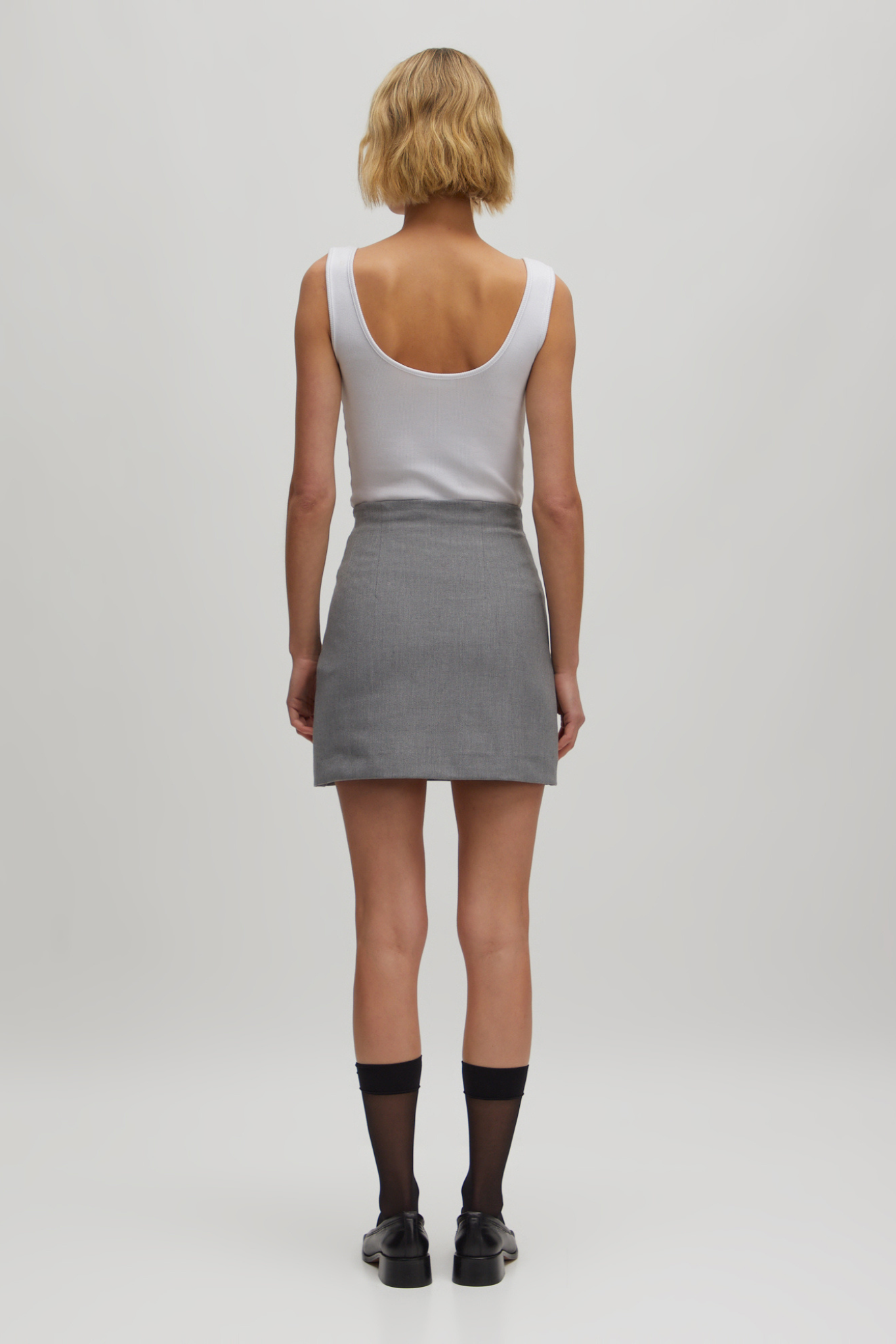 Model wearing the Edited Josie skirt in grey melange. Back view