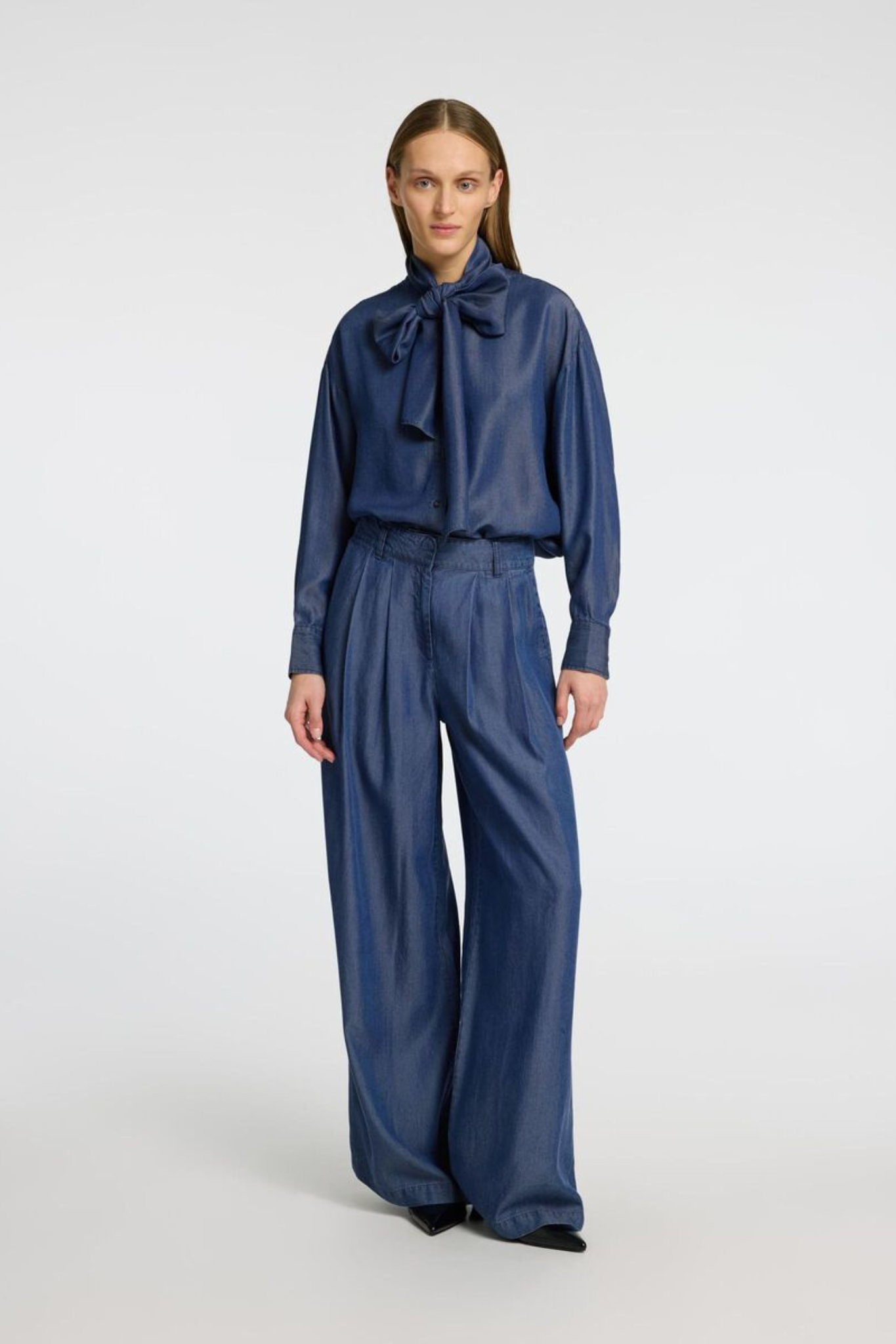 Model wearing the Selected Femme janna pleated chambray pants in dark blue. Front view